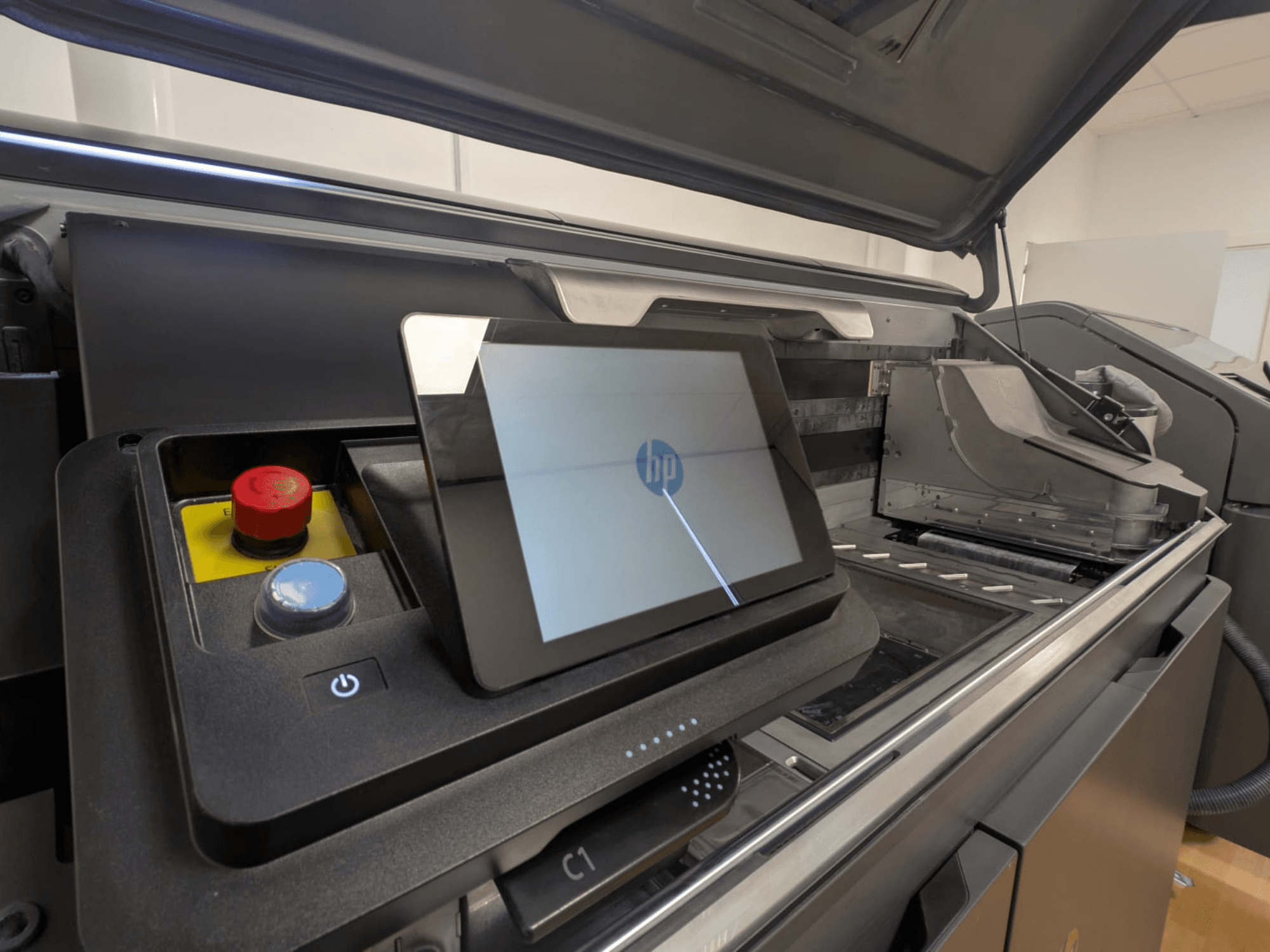 HP-tulostimen ohjauspaneeli, jossa näkyy tablettinäyttö, punaiset ja siniset painikkeet sekä sivukuva tulostimen sisäosista.