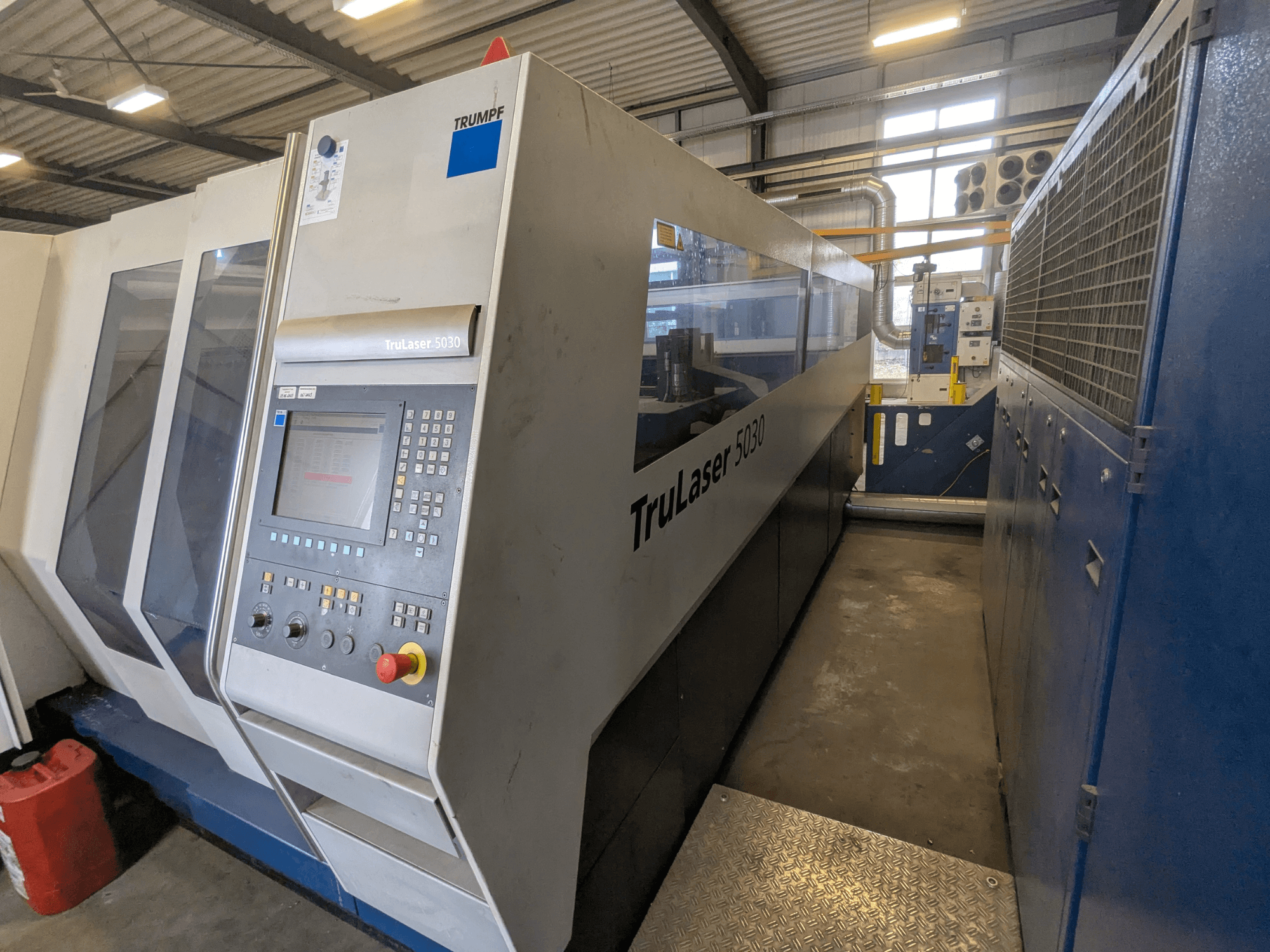 TRUMPF TruLaser 5030 CO2-laserleikkauskone, etukuva, jossa näkyy ohjauspaneeli ja tyylikäs muotoilu, teollisuusympäristössä.