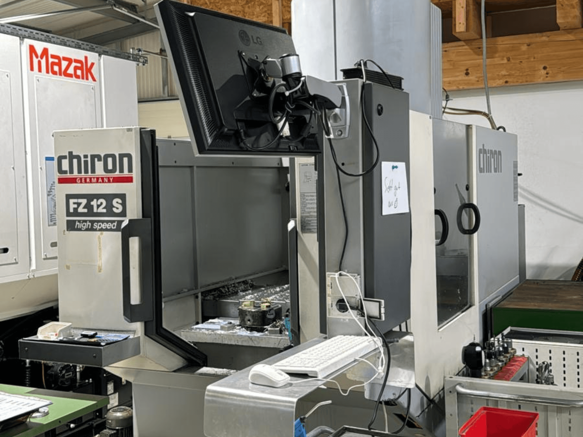 Pystykuva CHIRON FZ 12 S -nopeakoneistuskeskuksesta, jossa on ohjausnäyttö ja työstöprosessin roskia.