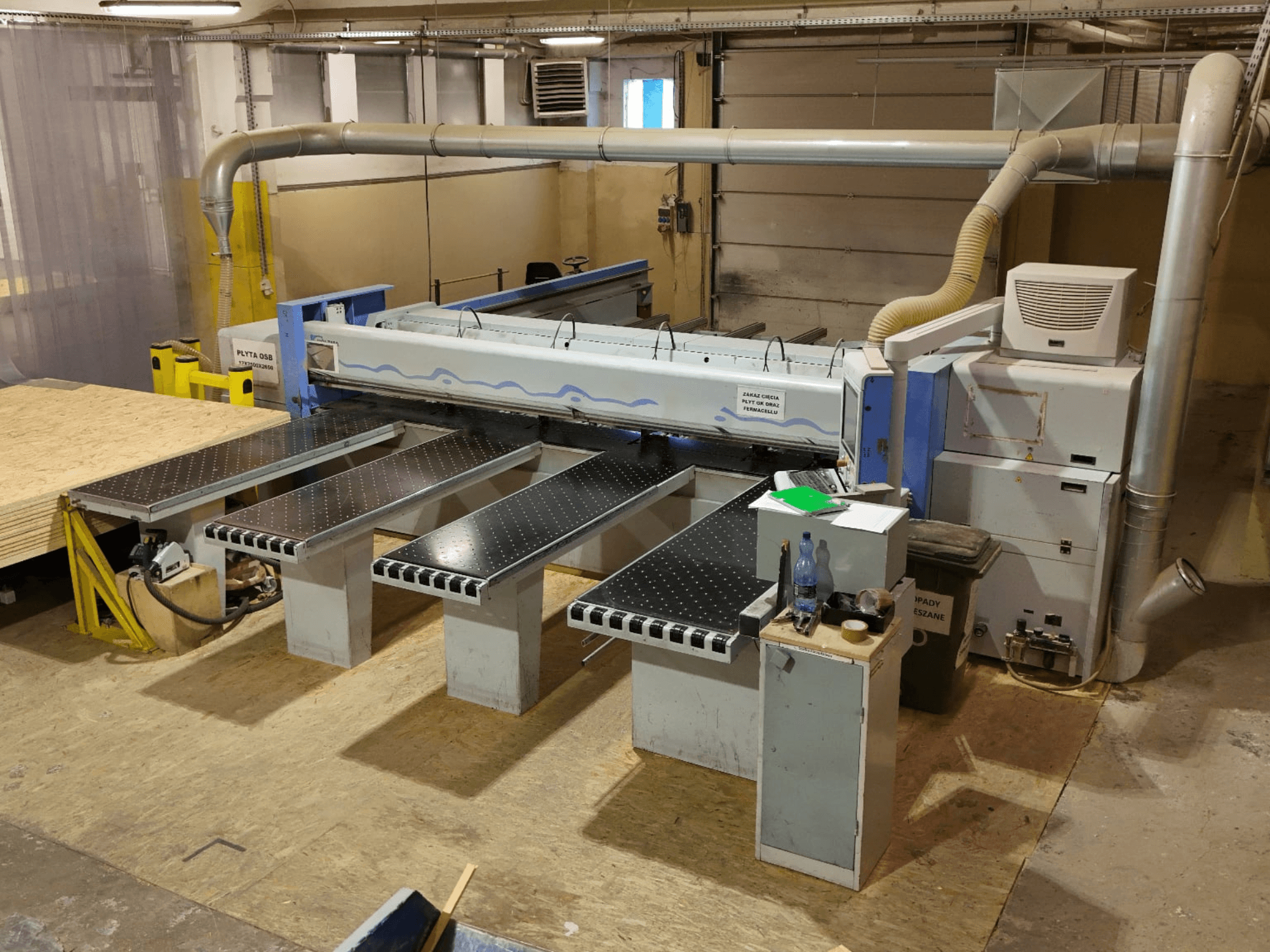 HOLZMA HPP 350/43/38 -levysaha työpajassa, ylhäältä katsottuna; kuvassa näkyvät sahausalue ja tukipöydät.