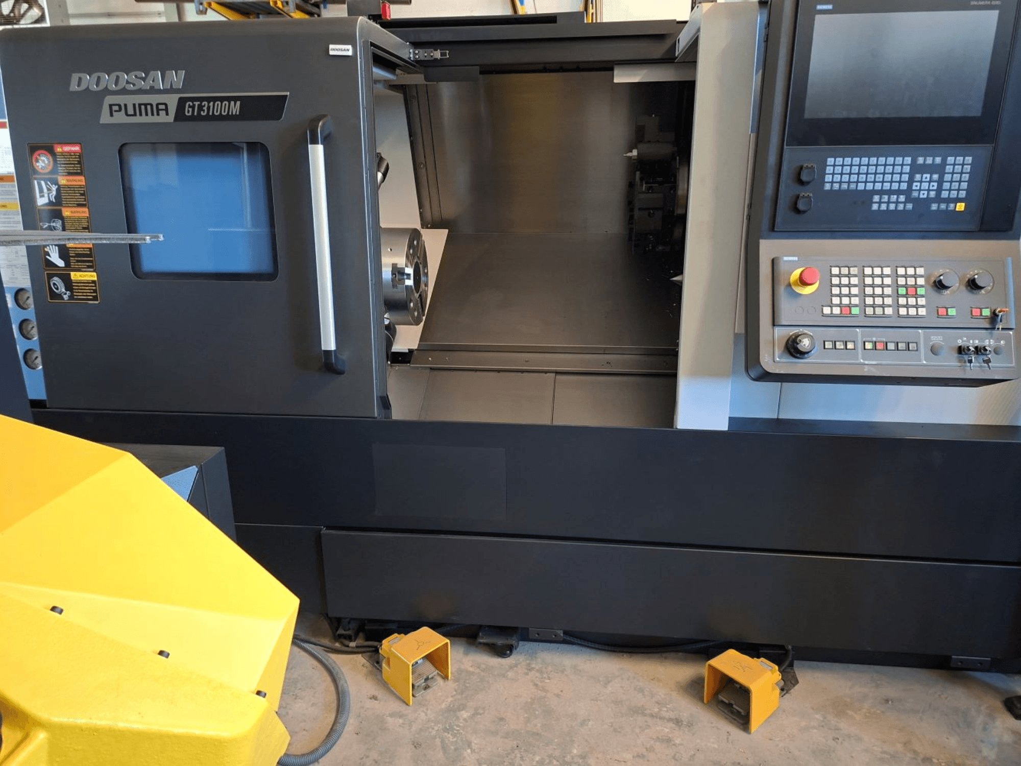 DOOSAN Puma GT 3100 M -vaakasorvauskone edestä katsottuna, jossa näkyy ohjauspaneeli, avoin torni ja sisätyötila.