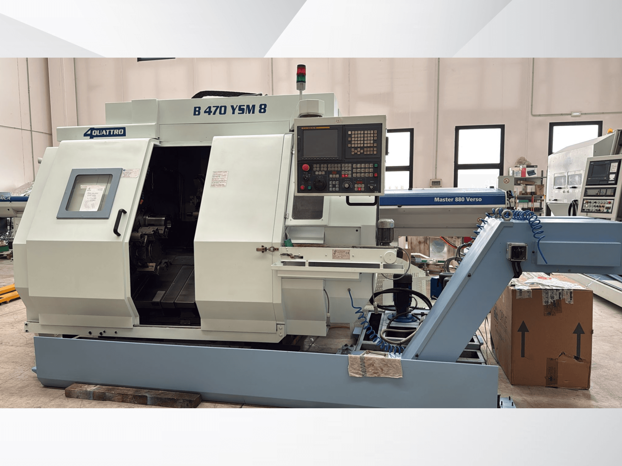 Biglia B470 YSM -kääntökeskus, etukuva, jossa näkyy ohjauspaneeli, avattu luukku ja työtila, jonka sisällä on työkaluja.