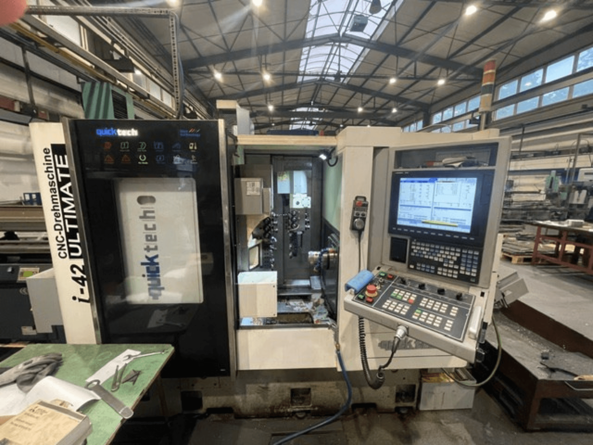 Quick-Tech I-42U sveitsiläistyyppinen sorvauskone, etukuva, jossa näkyy ohjauspaneeli ja CNC-käyttöliittymä työpajassa.