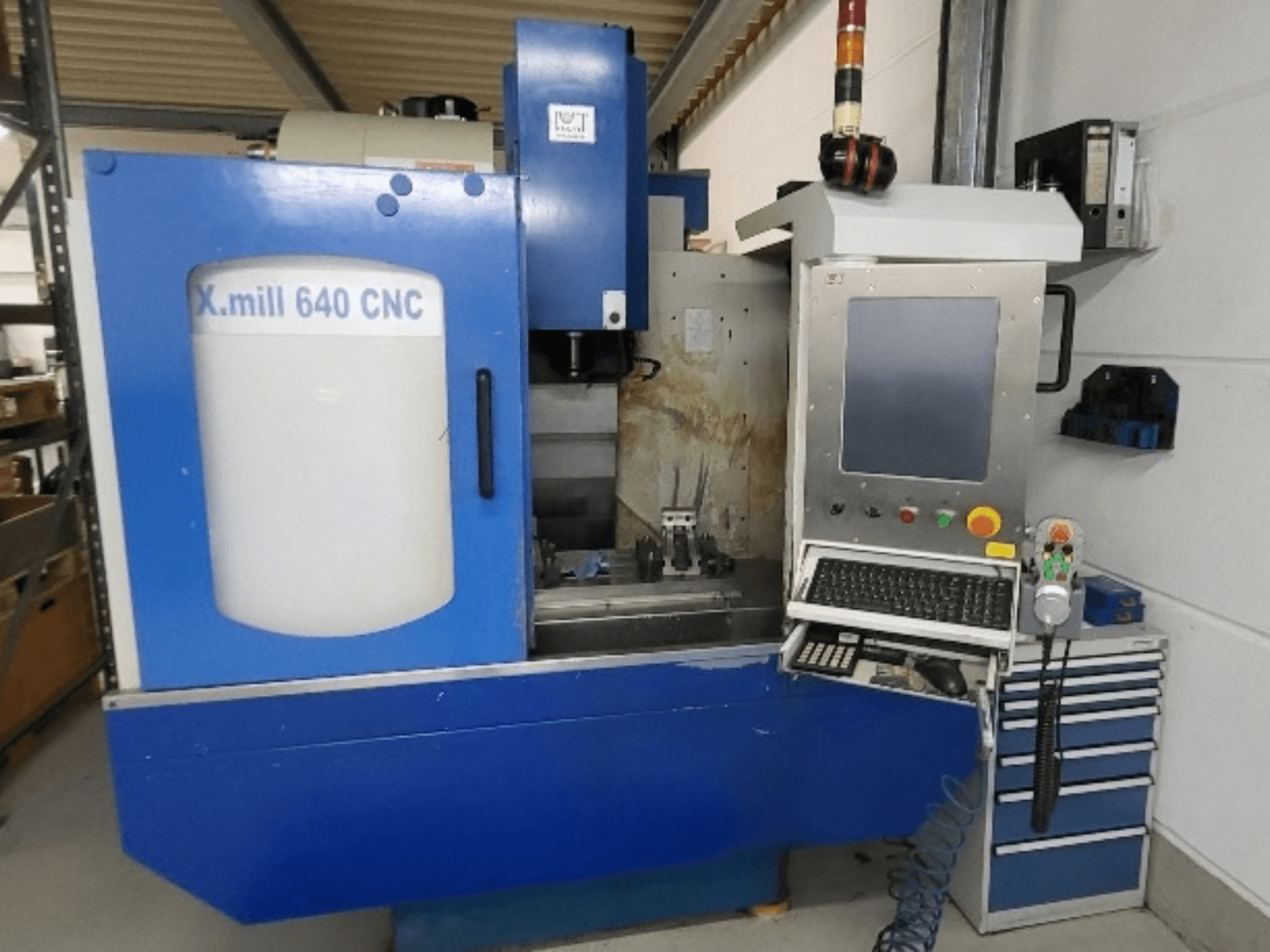 Sininen KNUTH X-mill 640 CNC-pystykoneistuskeskus, etunäkymä, jossa näkyvät ohjauspaneeli ja näppäimistö.