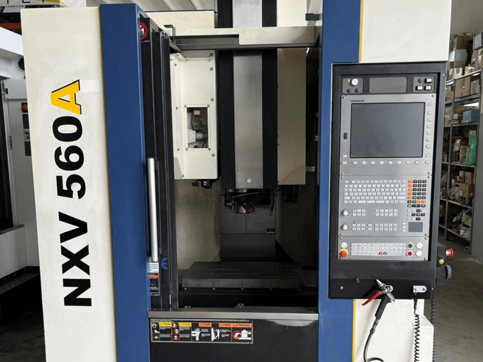 NXV 560A CNC-kone edestä katsottuna, jossa on ohjauspaneeli, jossa on painikkeet ja digitaalinäyttö.