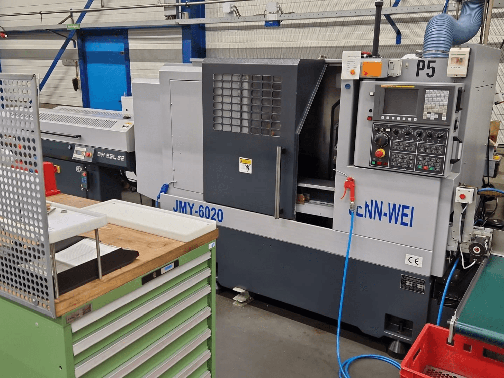 CNC-sorvi, malli JMY-6020, cNN-WEI, edestä katsottuna. Ohjauspaneeli, hätäpysäytys ja jäähdytysnestelinja.
