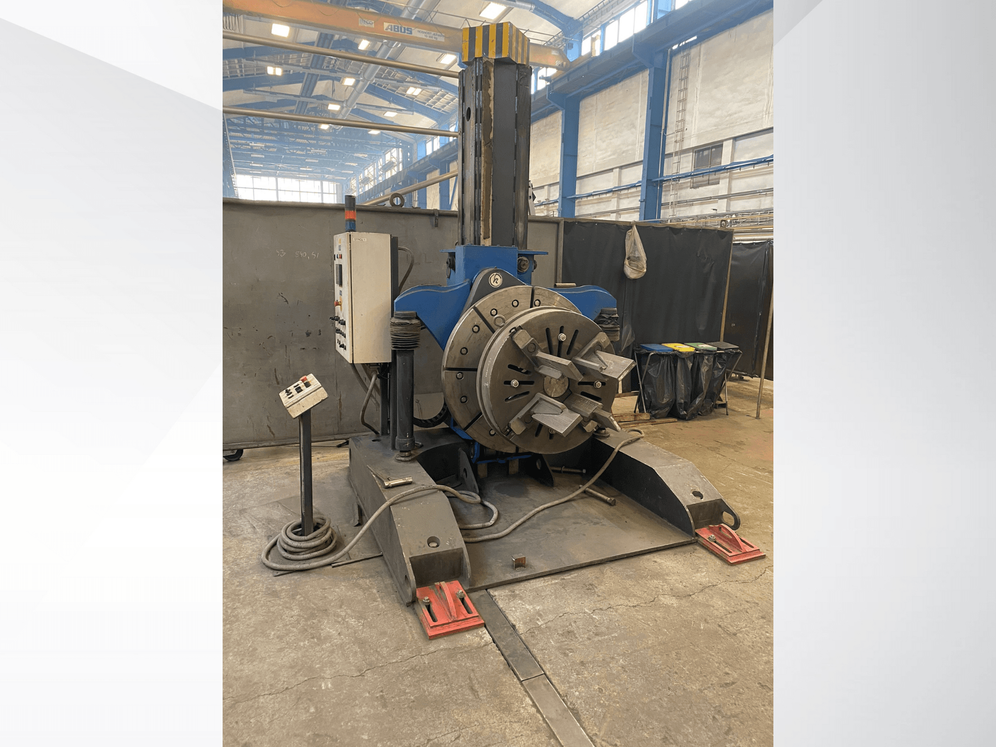 Sininen teollinen sorvi, jossa on pyöreä pyörivä pää ja ohjauspaneeli, sivukuva, työpajassa.