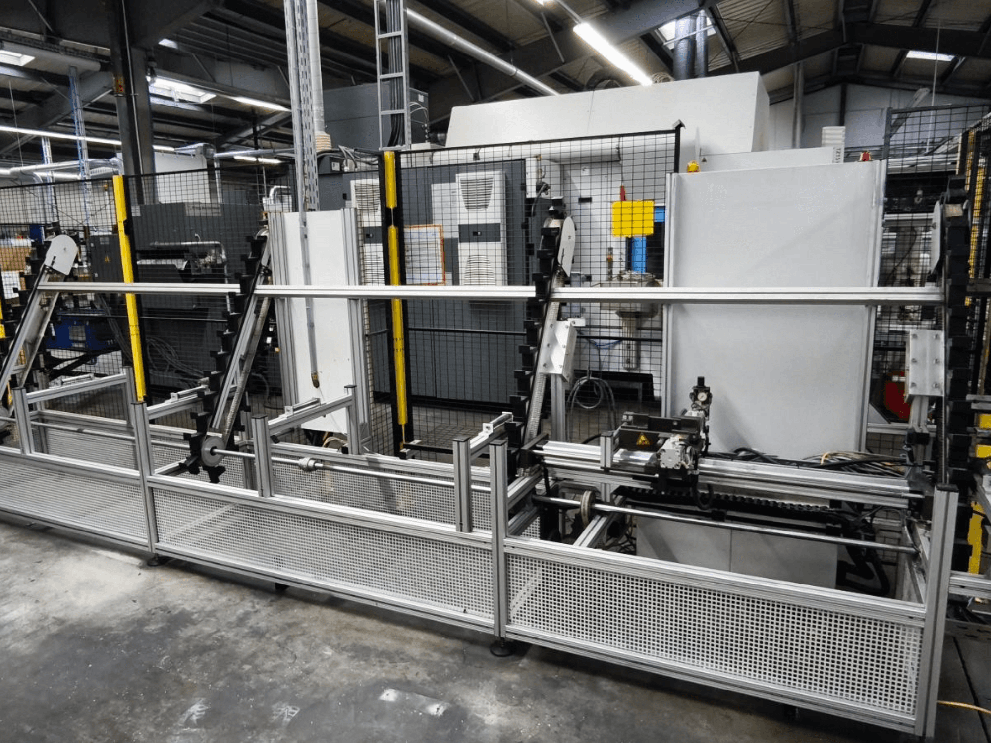 LOHMEIER Schräglademagazin -työkappaleenkäsittelyjärjestelmä edestäpäin, jossa näkyy sen metallirakenne ja integroidut mekaaniset komponentit.