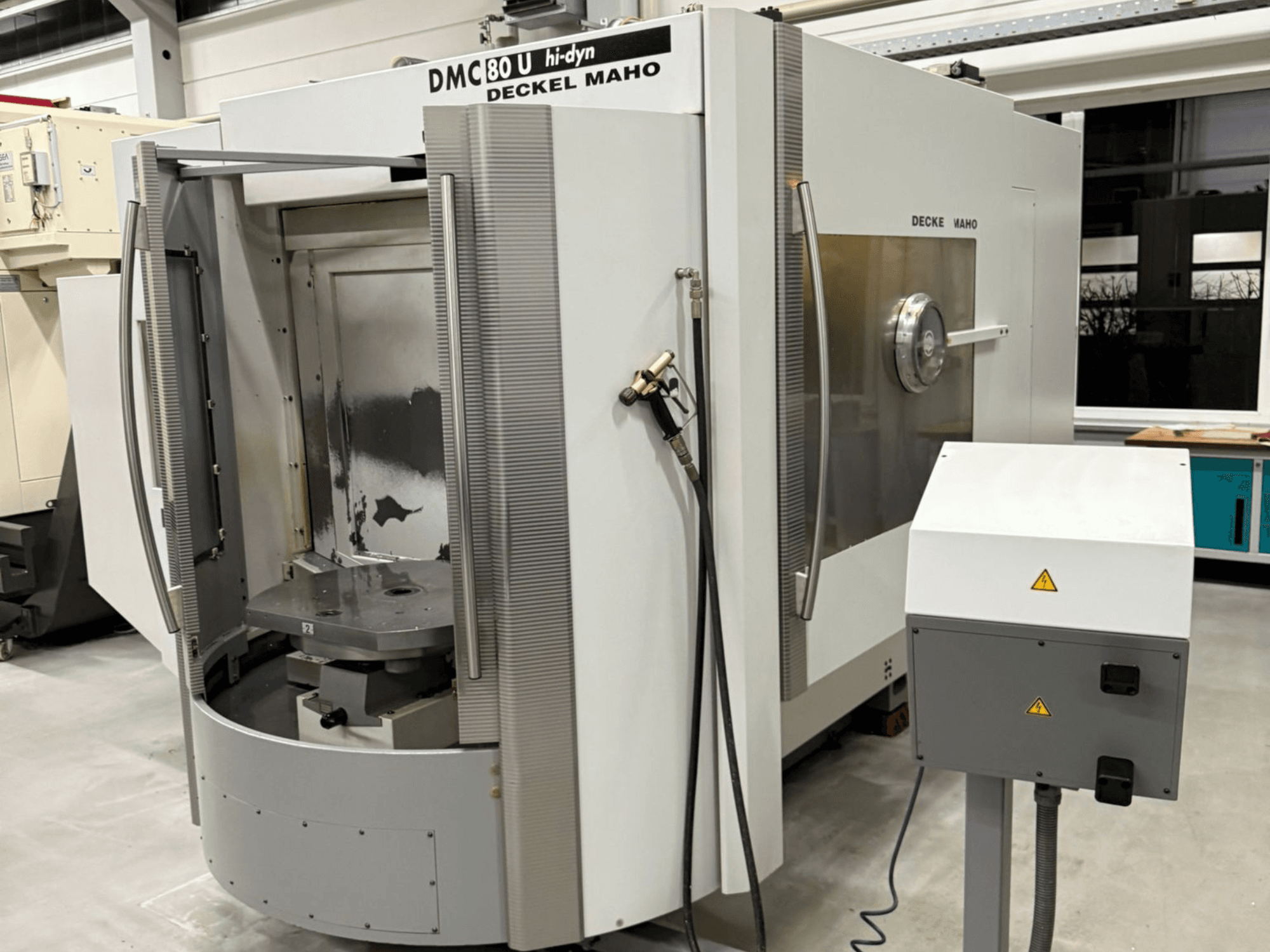 Deckel Maho DMC 80 U -nopean CNC-jyrsinkoneen etukuva, jossa on avoin ovi ja ohjauspaneeli sivulla.