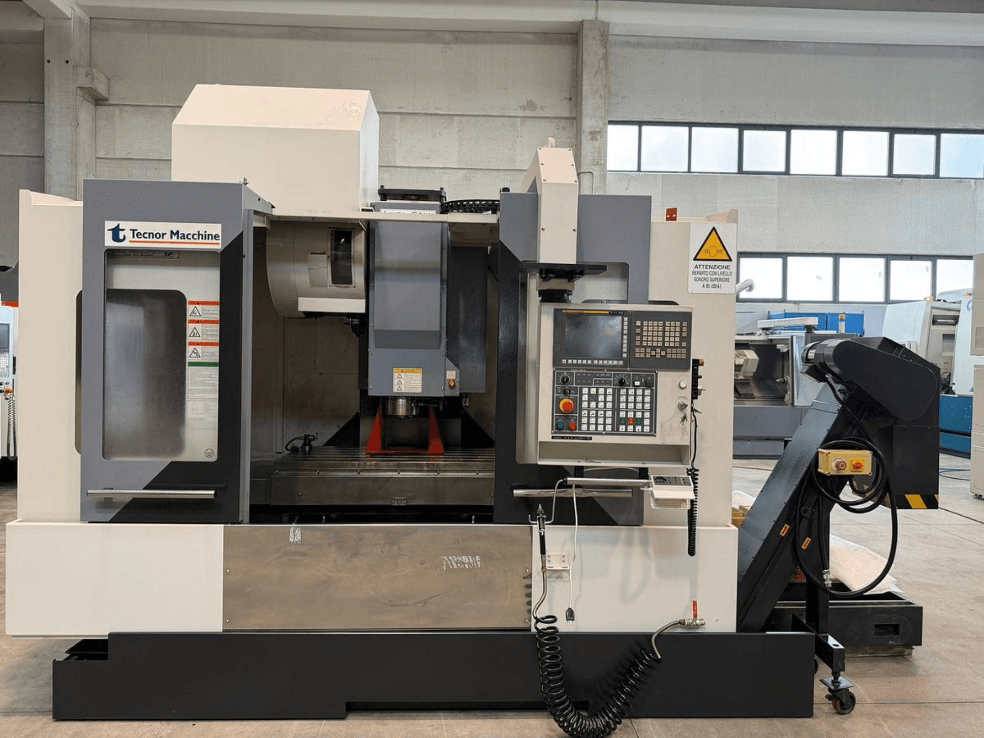 Tecnor Machine CNC-jyrsinkone, etukuva, jossa on ohjauspaneeli, jossa on painikkeet, varoitustarrat ja työkalunpidin.
