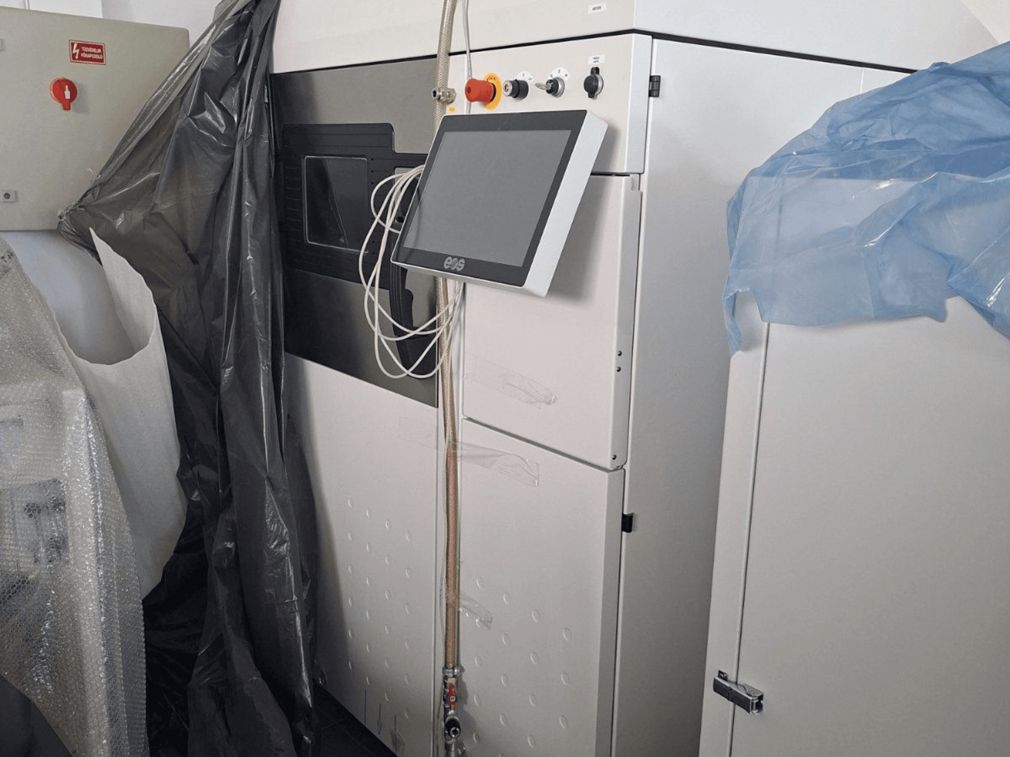 EOS M 290 -metalli-3D-tulostimen etukuva, jossa on kosketusnäyttö, ohjauspaneeli ja suojakuoret.