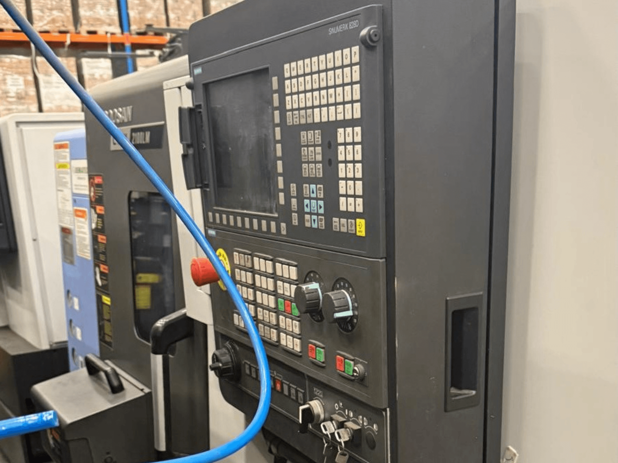 Koneistustyökalun ohjauspaneeli, etukuva, jossa on painikkeita, nuppeja ja digitaalinen näyttö tarkkaa käyttöä varten.