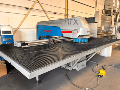 Euromac MTX FLEX 12 CNC-lävistyskone, etunäkymä, jossa on suuri rei’itetty pöytä ja ohjauspaneeli.