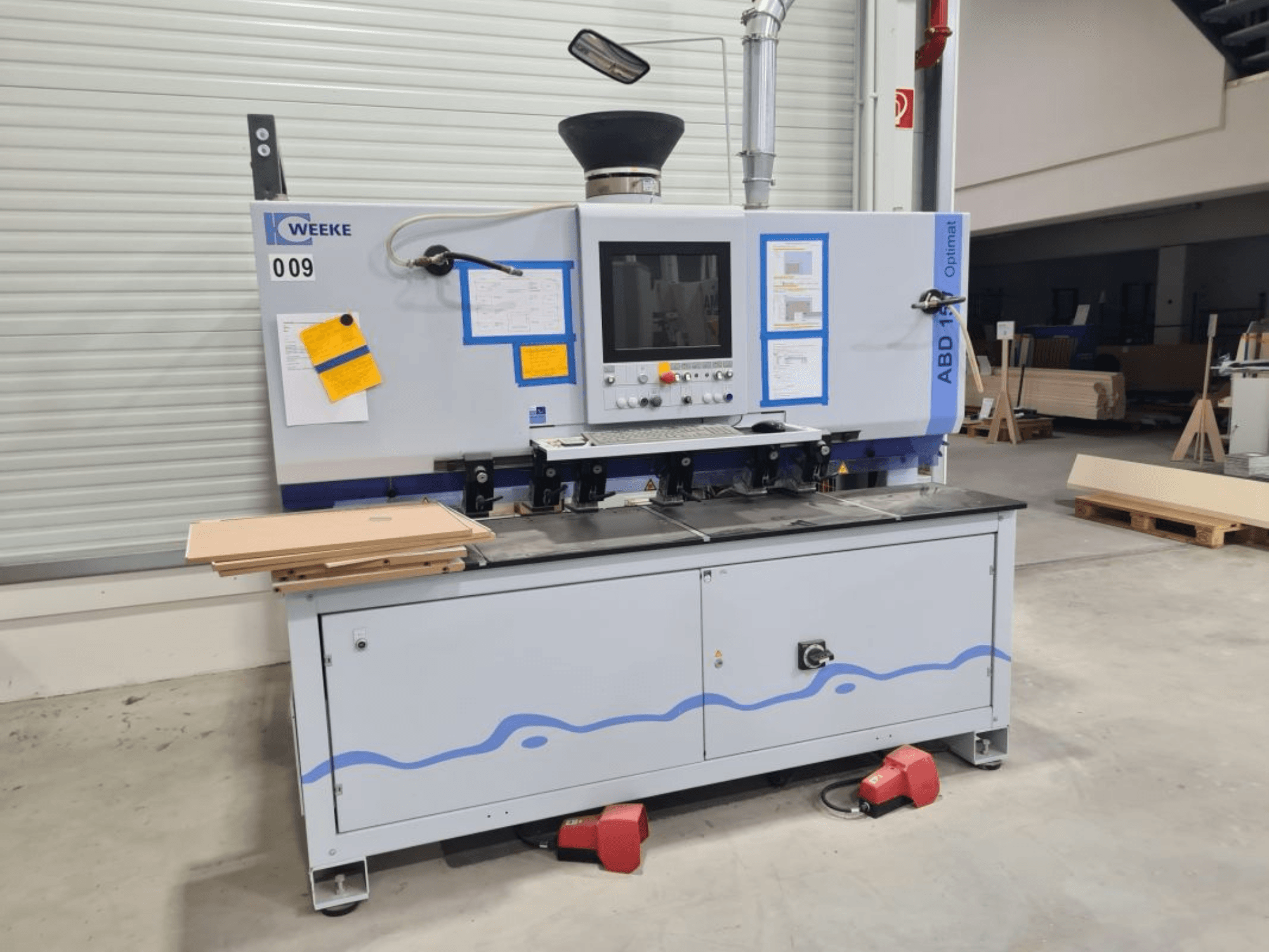 HOMAG WEEKE OPTIMAT ABD150 monikarainen porakone, etukuva, jossa näkyy hallintalaitteet ja pinotut puulevyt.