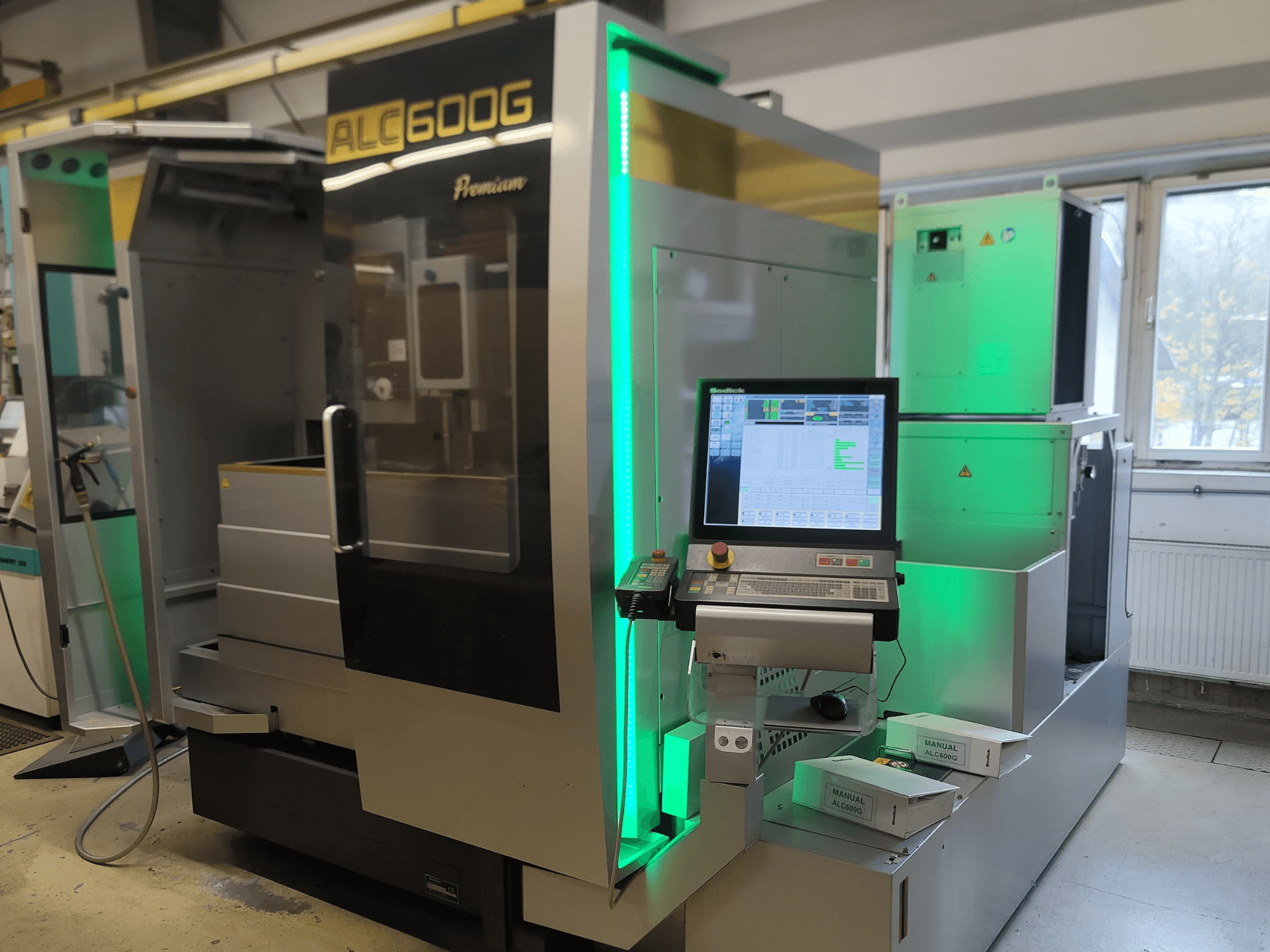 Sodick ALC600G Premium Wire EDM -kone, etukuva, jossa näkyy ohjauspaneeli ja valaistut ulkoiset yksityiskohdat.