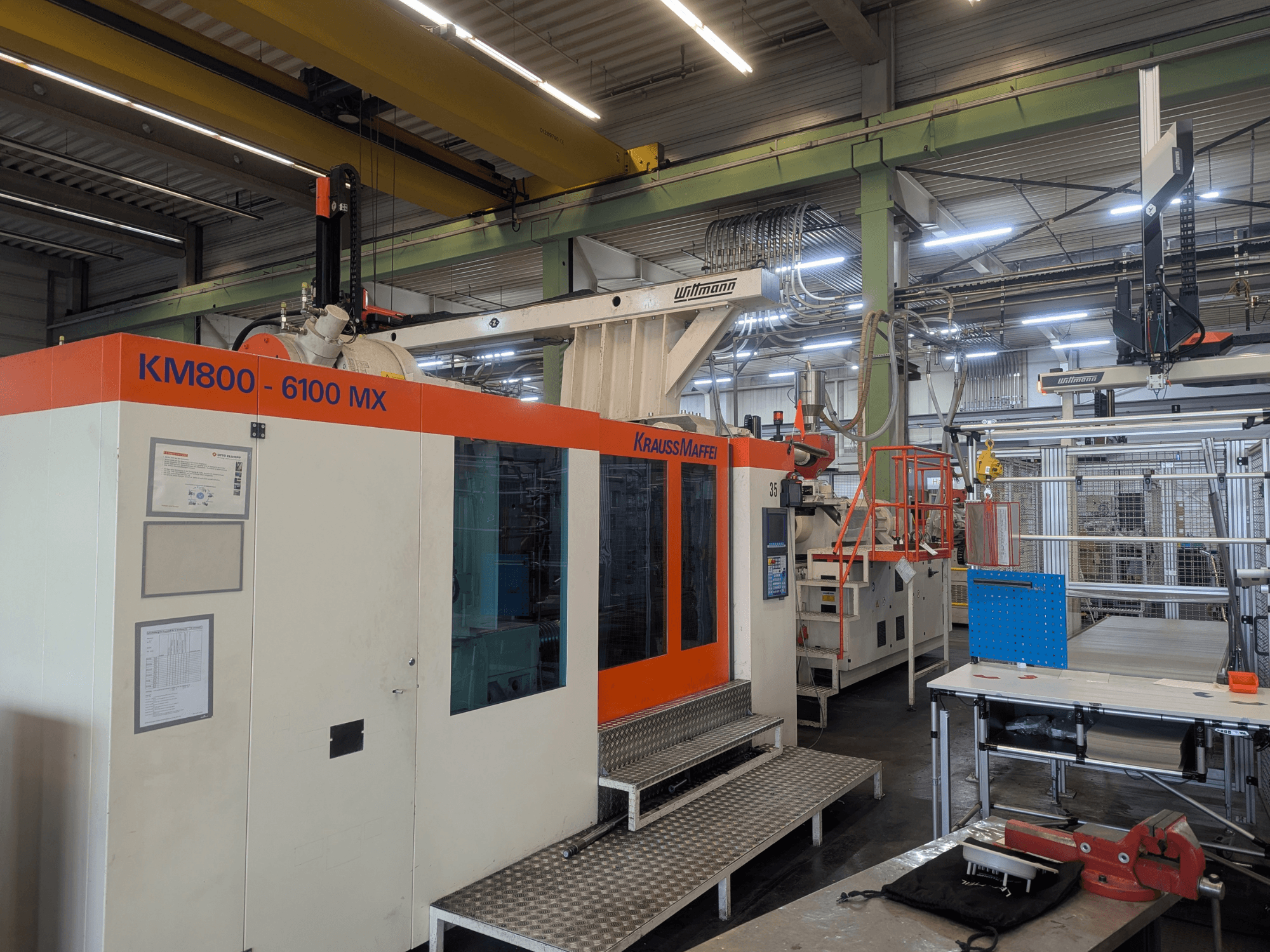 Krauss Maffei KM 800-6100MX hydraulinen ruiskuvalukone, etukuva, jossa näkyy ohjauspaneeli ja teollisuusasetukset.