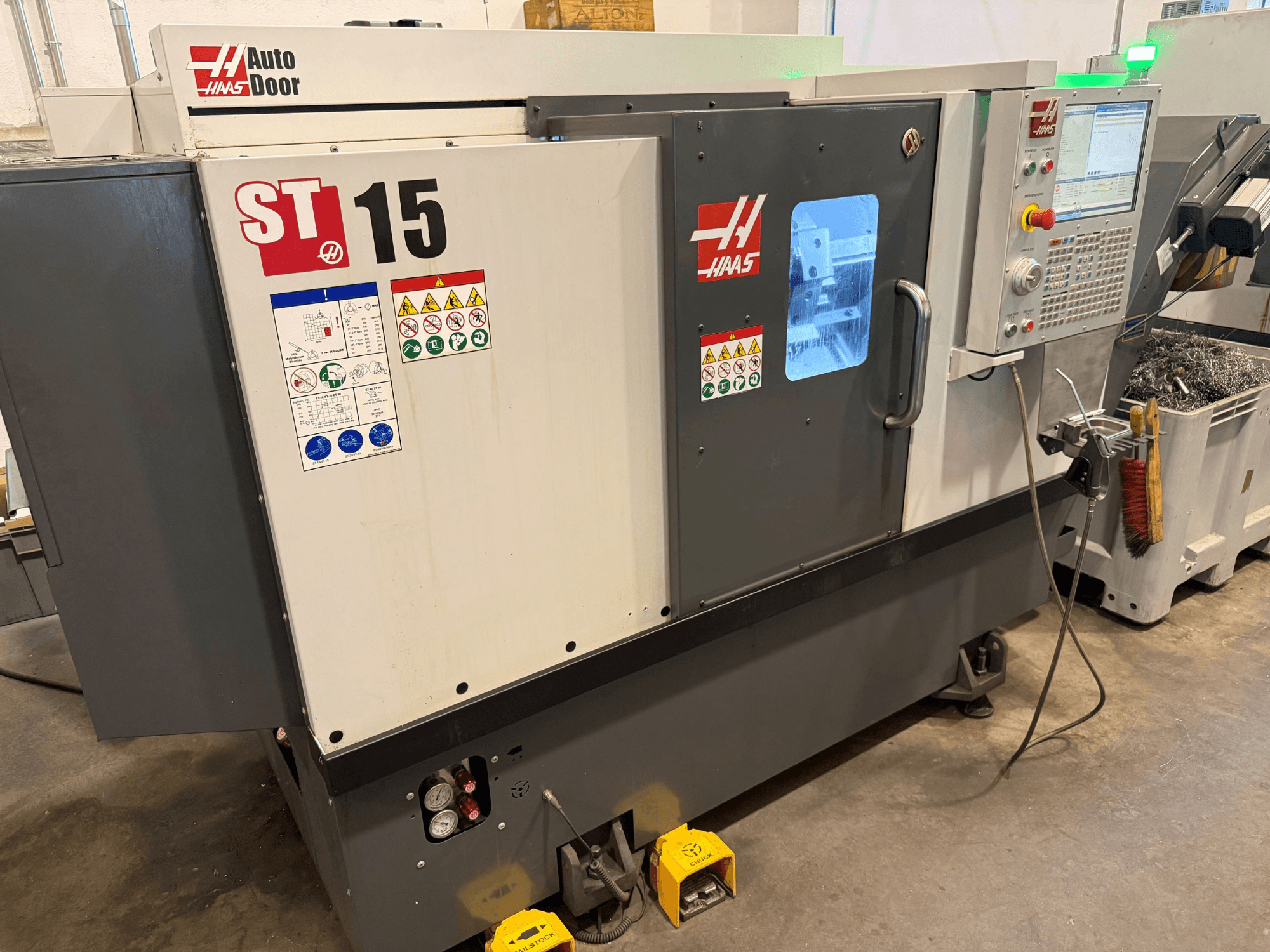 HAAS ST 15 -vaakasuora sorvi, etunäkymä, jossa näkyvät ohjauspaneeli, automaattiovi ja tekniset mittarit.