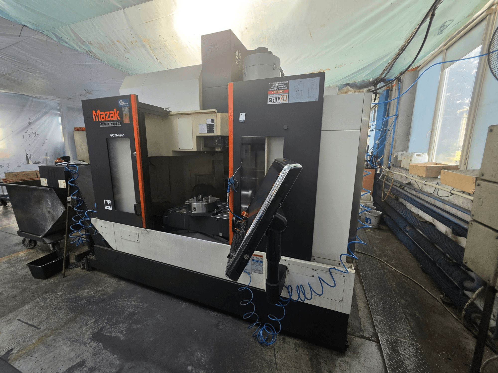Mazak VCN-530C -pystykoneistuskeskus edestä katsottuna; kuvassa näkyvät ohjauspaneeli, työstöalue ja työkalunpidin.