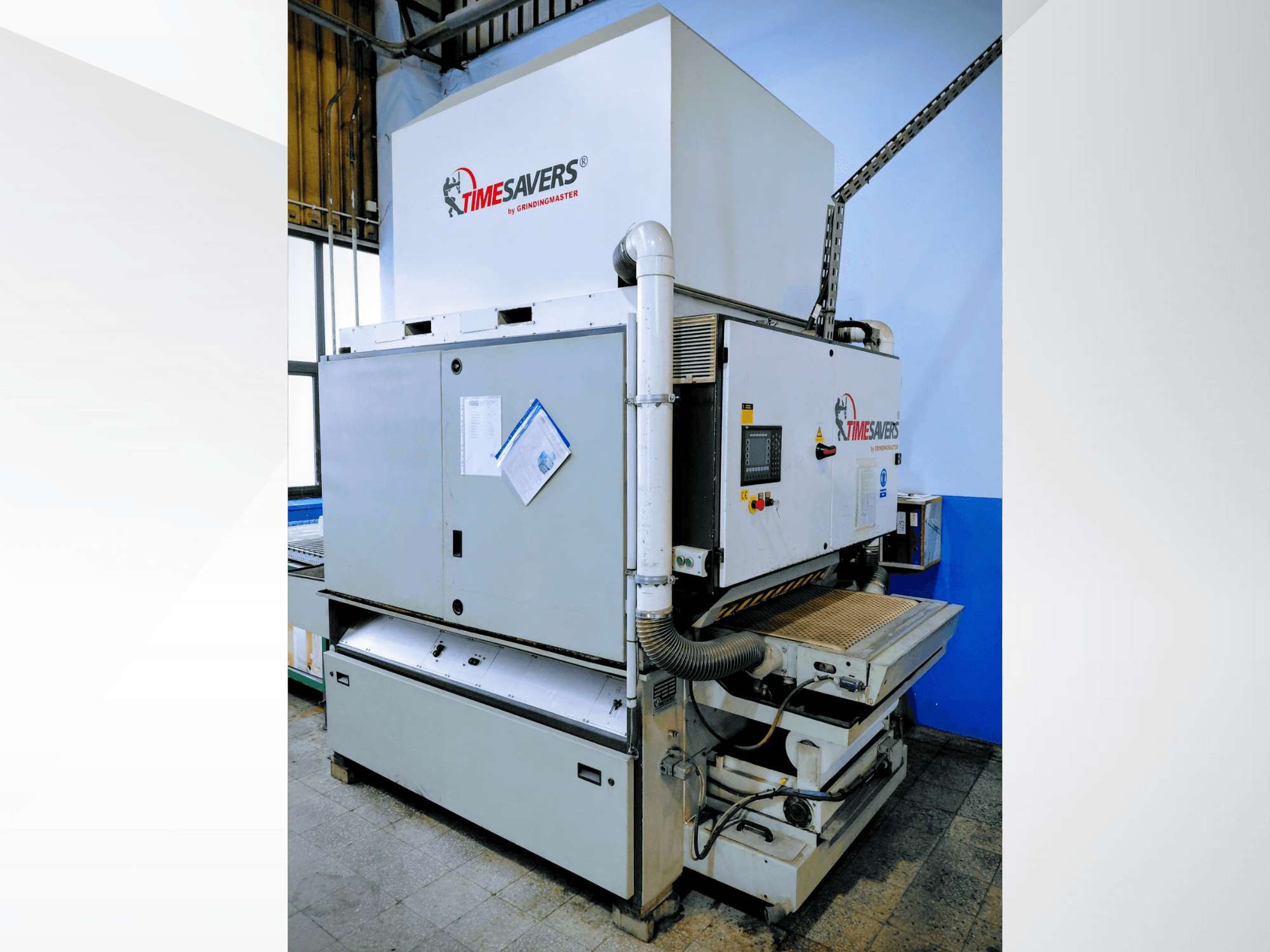 Timesavers-teollisuushiomakone, etukuva. Toiminnalliset hallintalaitteet, pölynpoisto ja säädettävä hiomapenkki tarkkuutta varten.