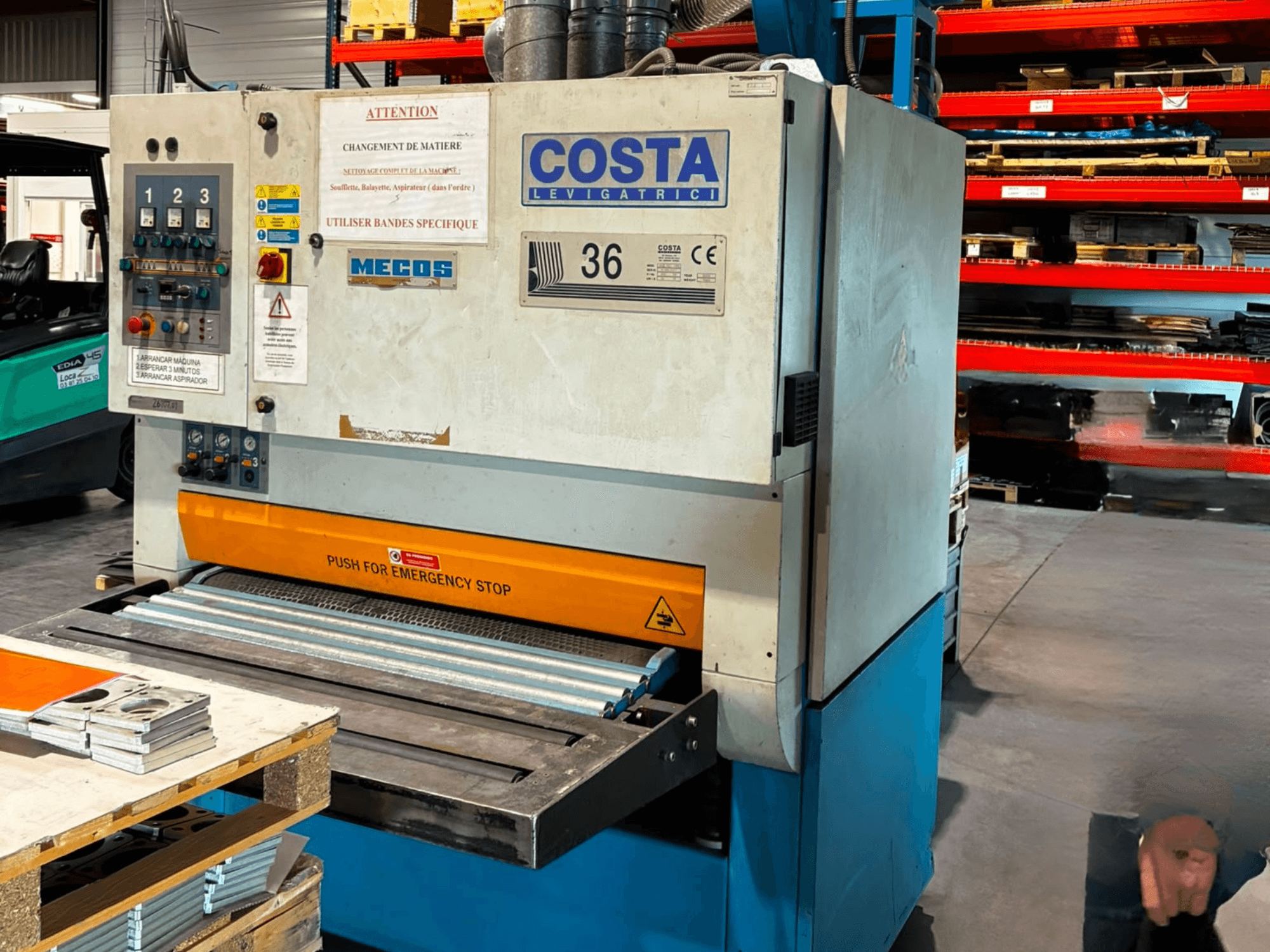 Costa M36 CCS 1150 -purseenpoistokone sivulta katsottuna; kuvassa näkyvät ohjauspaneeli, hätäpysäytyspainike ja kuljetinpinta.