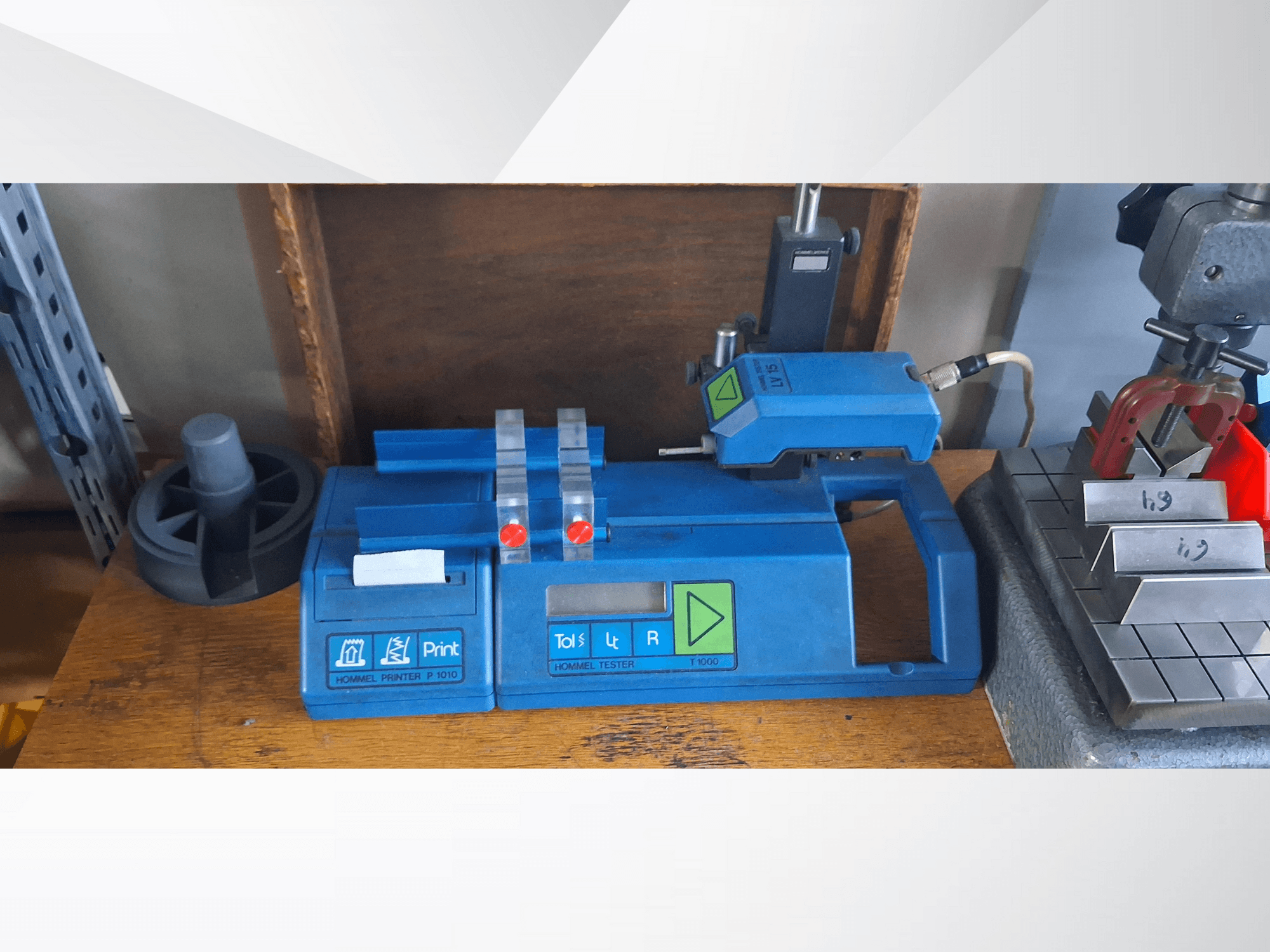 Hommel Printer P 1010 ja Tester T1000 sivukuvassa, sininen kotelo, painikkeet ja punaiset merkkivalot, työpöydällä.