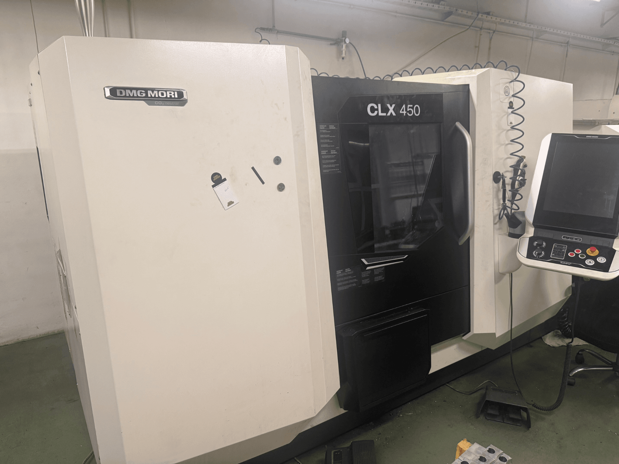 DMG MORI CLX 450 CNC-kone, sivukuva, jossa ohjauspaneeli, näkyvät käyttöpainikkeet ja puhdas työtila.