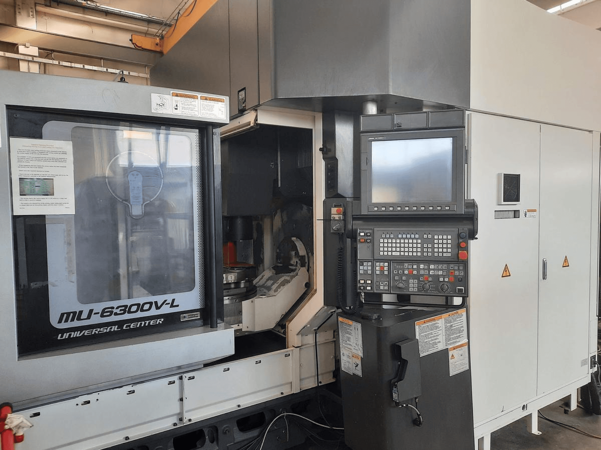 MU-6300V-L Universal Center -kone edestäpäin, ohjauspaneeli, näyttö ja käyttöohjeet näkyvissä.