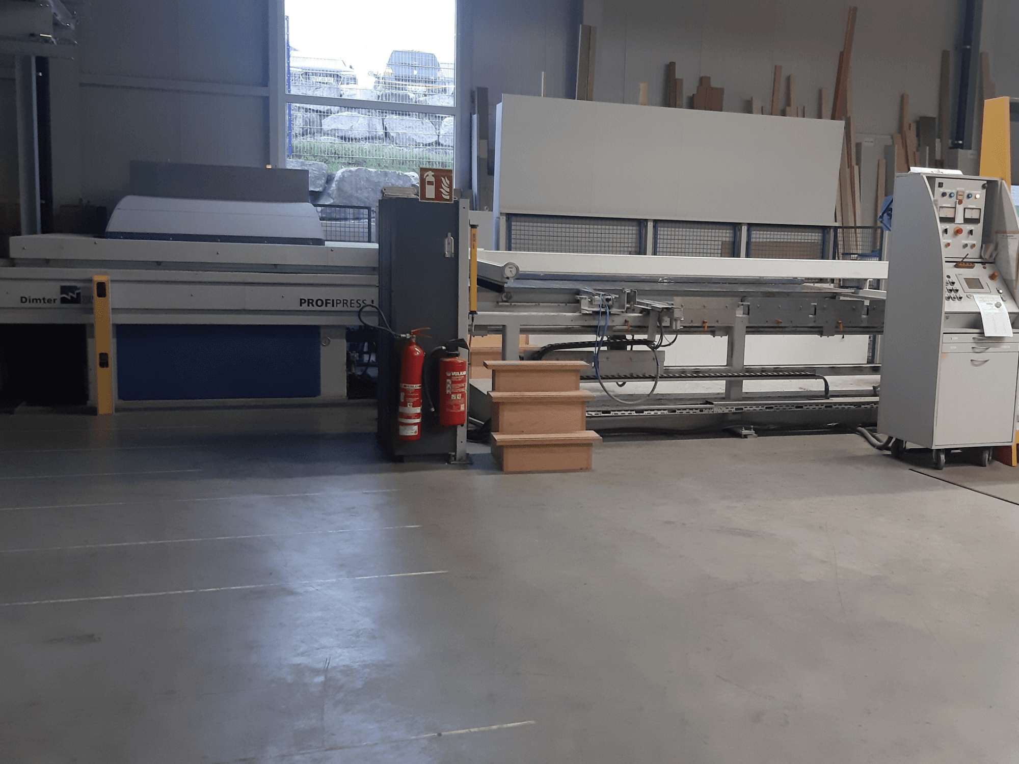 Dimter ProfiPress -kone korjaamolla edestä katsottuna, ohjauspaneeli ja palosammuttimet lähellä.