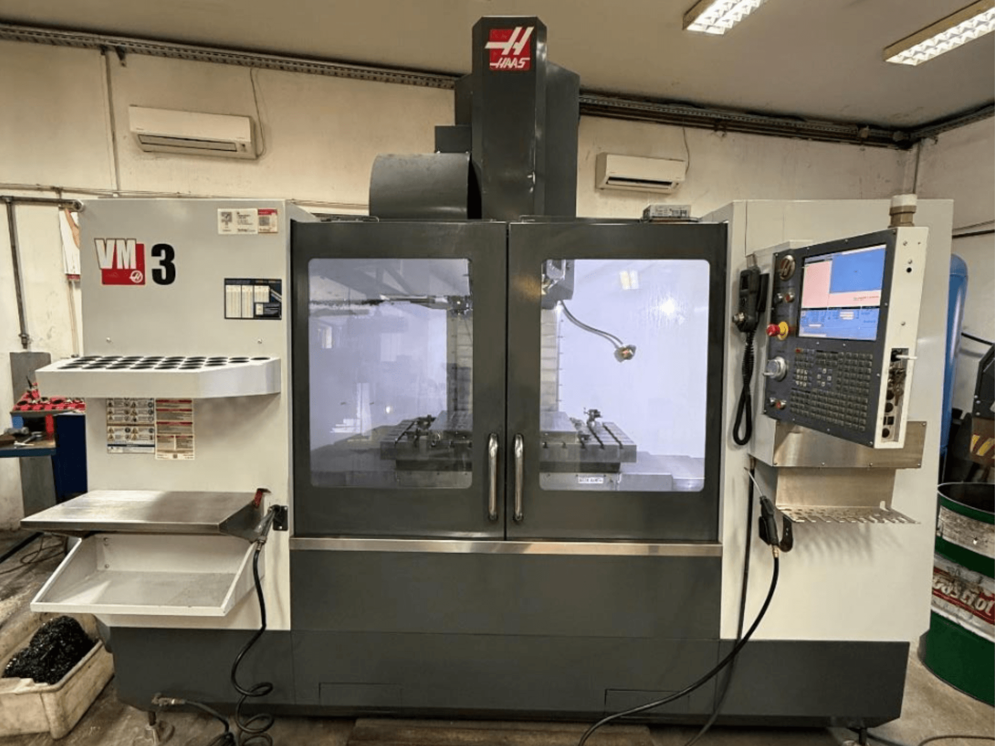 Haas VM-3 -pystykoneistuskeskus edestä katsottuna; kuvassa näkyy suuri ohjauspaneeli ja työkoneiden näkyvä työskentelyalue.