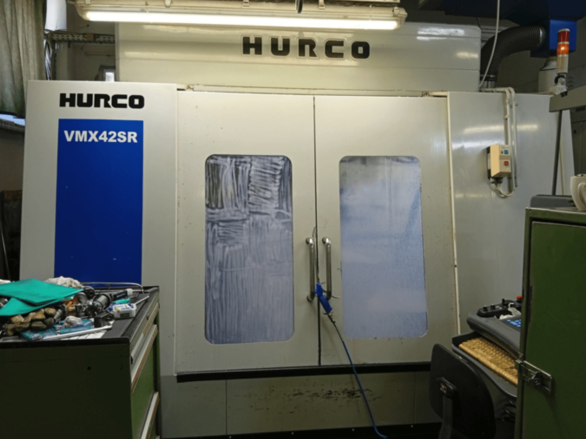 Hurco VMX 42SR -pystytyöstökeskus etukuvassa, jossa on sininen paneeli, ohjauskäyttöliittymä ja puhdas työtila.