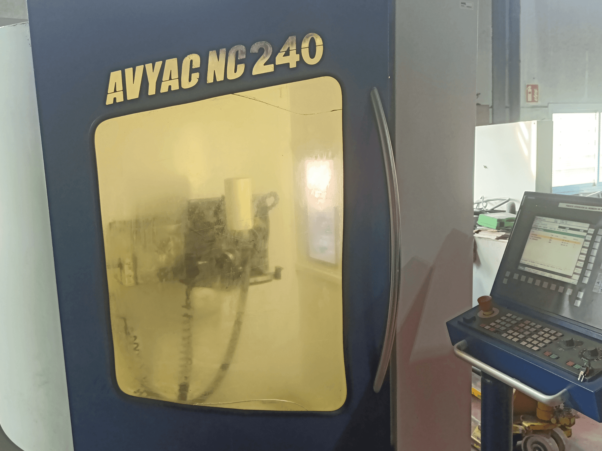AVYAC NC240 -lieriöhiomakone, sivukuva, jossa näkyy ohjauspaneeli ja ikkunan läpi osittain näkyvä hionta-alue.
