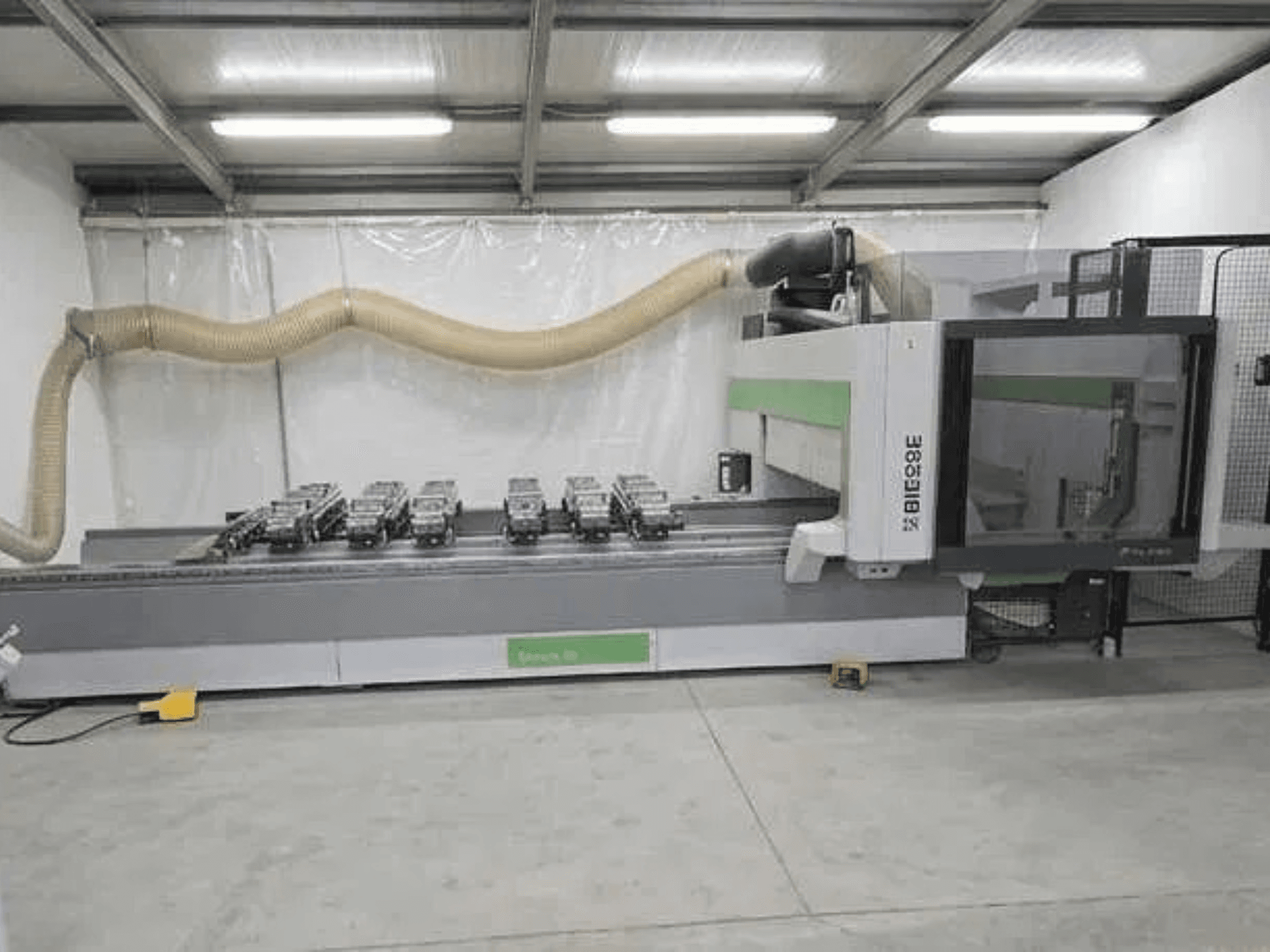 BIESSE Rover K1232 CNC-työstökeskus sivulta katsottuna; kuvassa näkyvät tyhjiöimukupit ja pölynpoistojärjestelmä.