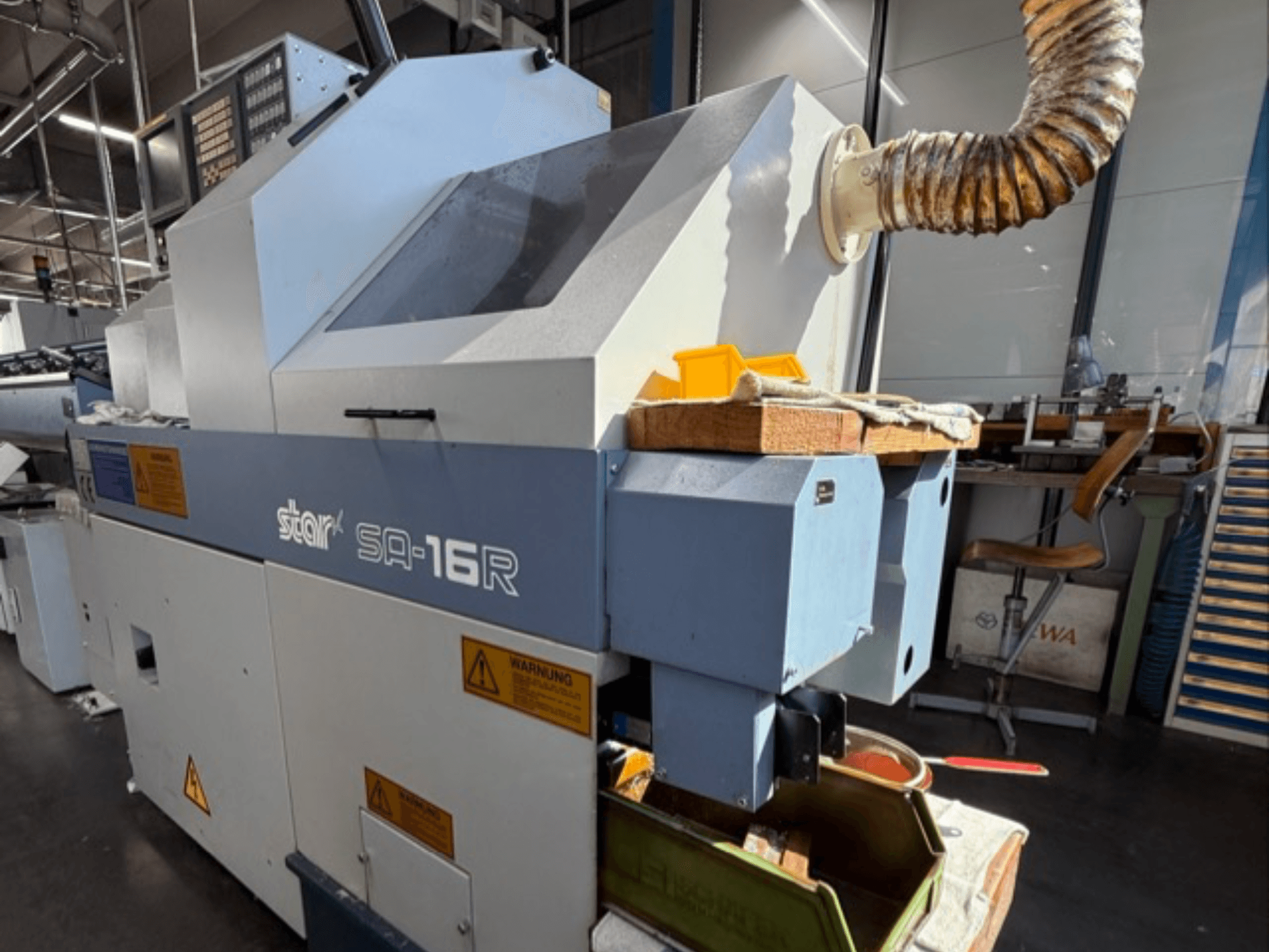 Stark SA-16R -kone edestä katsottuna, jossa on kartiomainen pakoputki ja työtila, jossa on keltaisia työkaluja ja varoitustarroja.