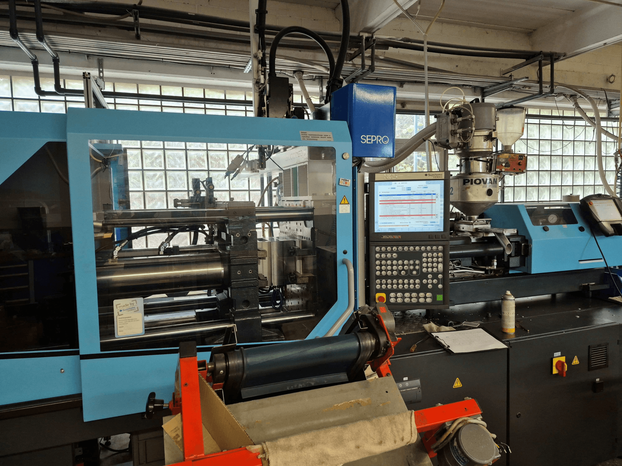 Hydraulinen ruiskuvalukone SUMITOMO SHI DEMAG Systec 120/470-430, etunäkymä, jossa näkyvät ohjauspaneeli ja syöttöjärjestelmä.