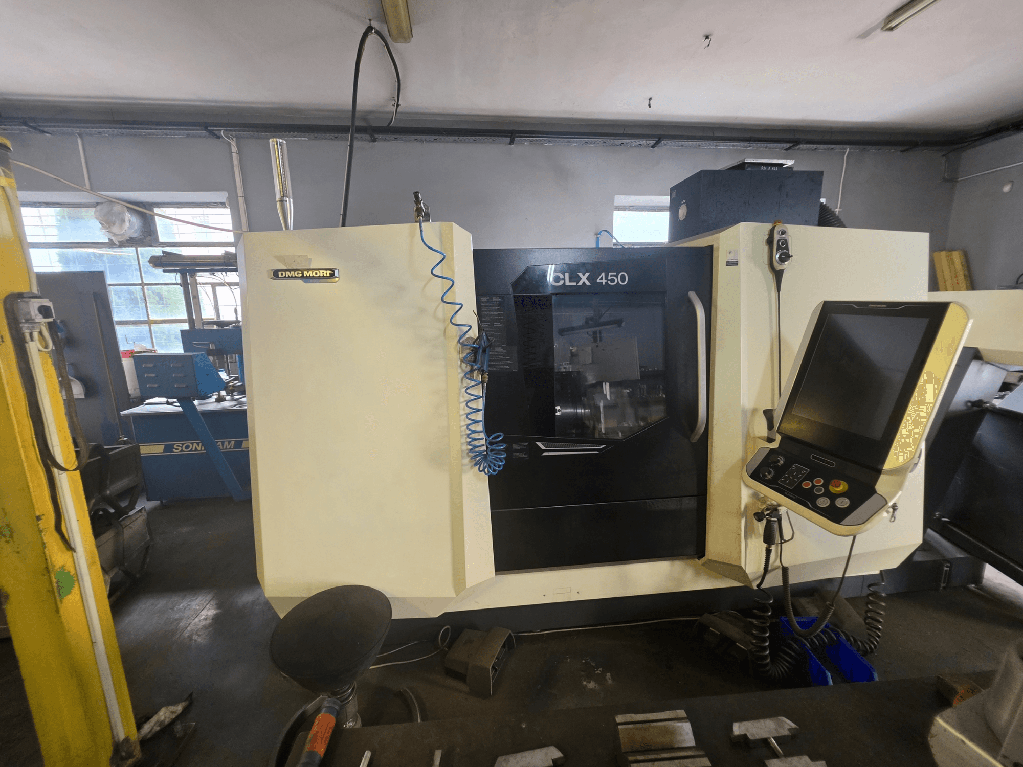 DMG MORI CLX 450 V6 -vaakasuora sorvi edestä katsottuna, ohjauspaneeli ja näkyvä tuotemerkki.