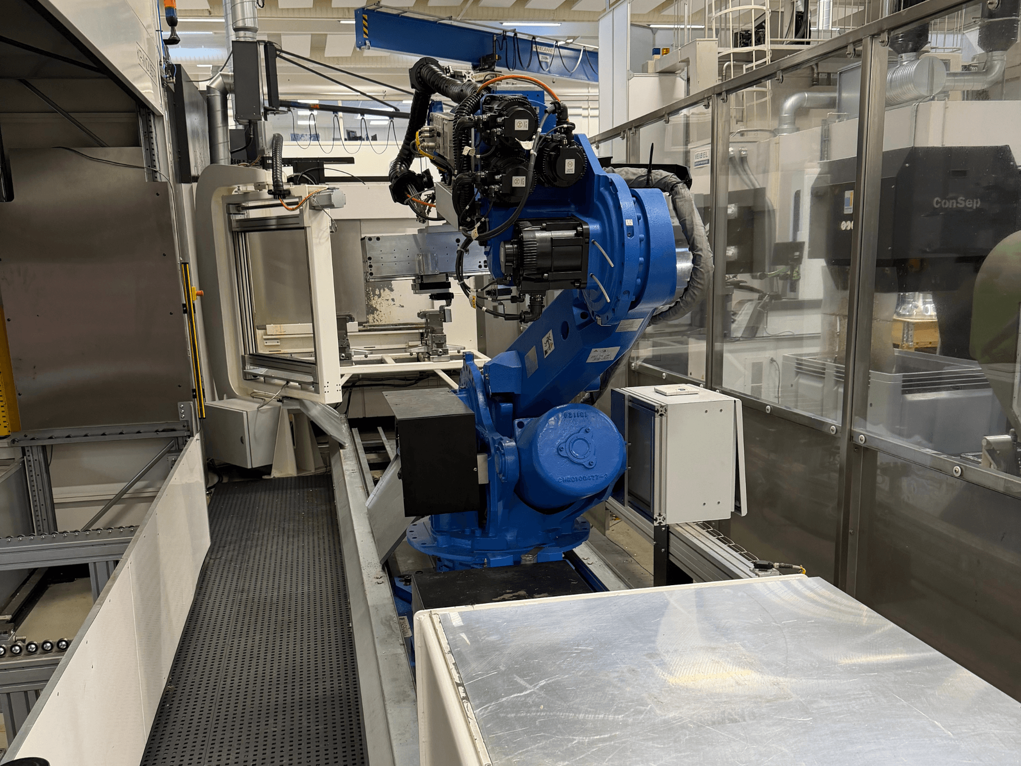 Yaskawa Motoman ES165D -robottivarsi kiskolla, sivukuva, jossa näkyy automaatioasetus teollisuusympäristössä.