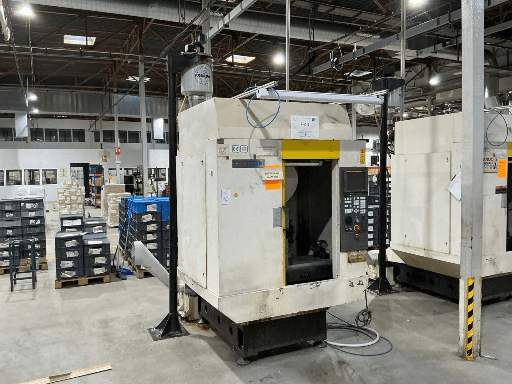 FANUC ROBODRILL α-T21iD, etukuva pystysuorasta työstökeskuksesta teollisuusympäristössä, ohjauspaneelin yksityiskohdat näkyvissä.