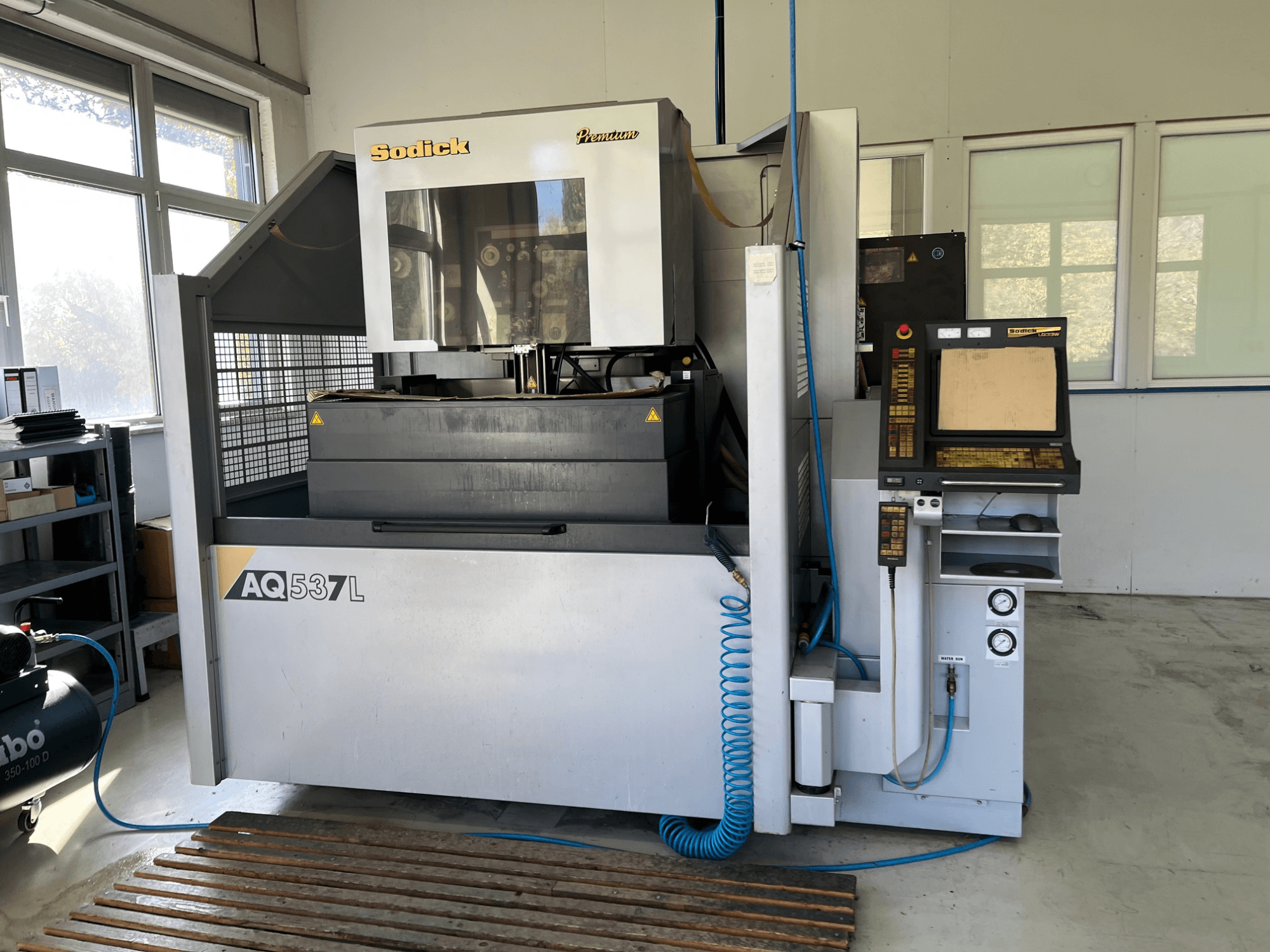 Sodick AQ537L -sähköpurkauskone (EDM) etukuvassa, jossa on ohjauspaneeli, vesijäähdytysputket ja työtila.