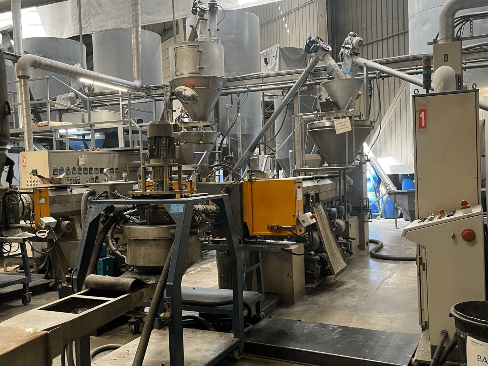 Yksiruuviekstruuderi EUROTECNO E12535D tehdasasennuksessa, jossa on prosessointikomponentit, syöttösuppilot ja ohjauspaneeli.