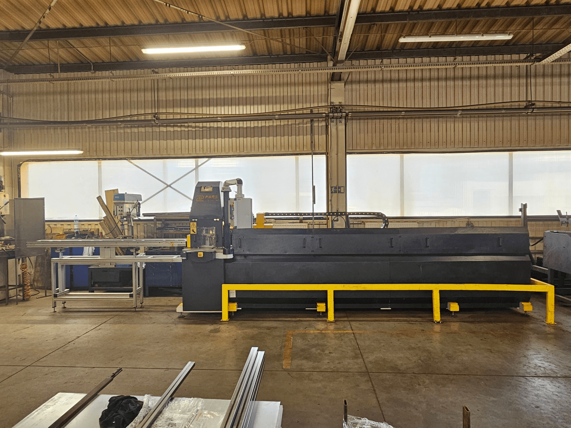 CNC-lävistyskone PARS HMP SIRIUS PLUS-3000/3-L1, etunäkymä teollisuusympäristössä, jossa näkyy metallipinta ja työkaluja.