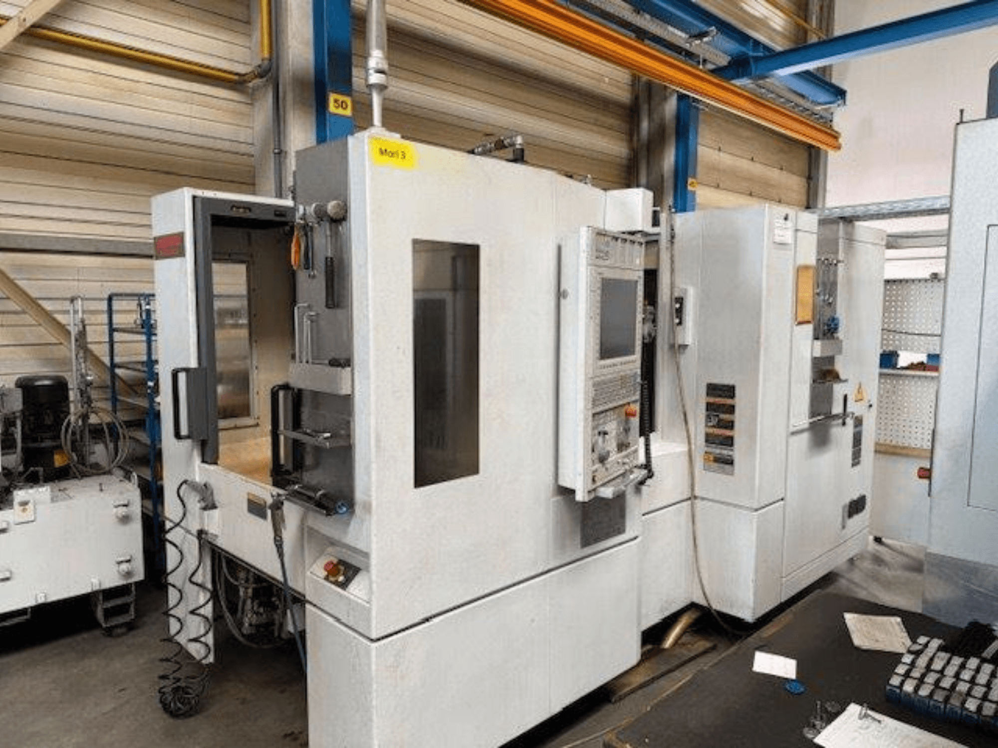 Etukuva MORI SEIKI NH4000 DCG -vaakakoneistuskeskuksesta, jossa on avoin ovi ja ohjauspaneeli näkyvissä ja jossa näkyy toimintatila.