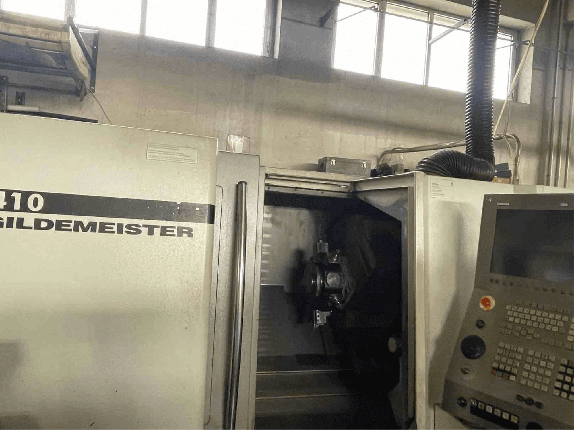 DMG CTX410 vaakasuuntainen sorvauskone, etukuva, jossa näkyy ohjauspaneeli ja sisällä näkyvät työstökomponentit.