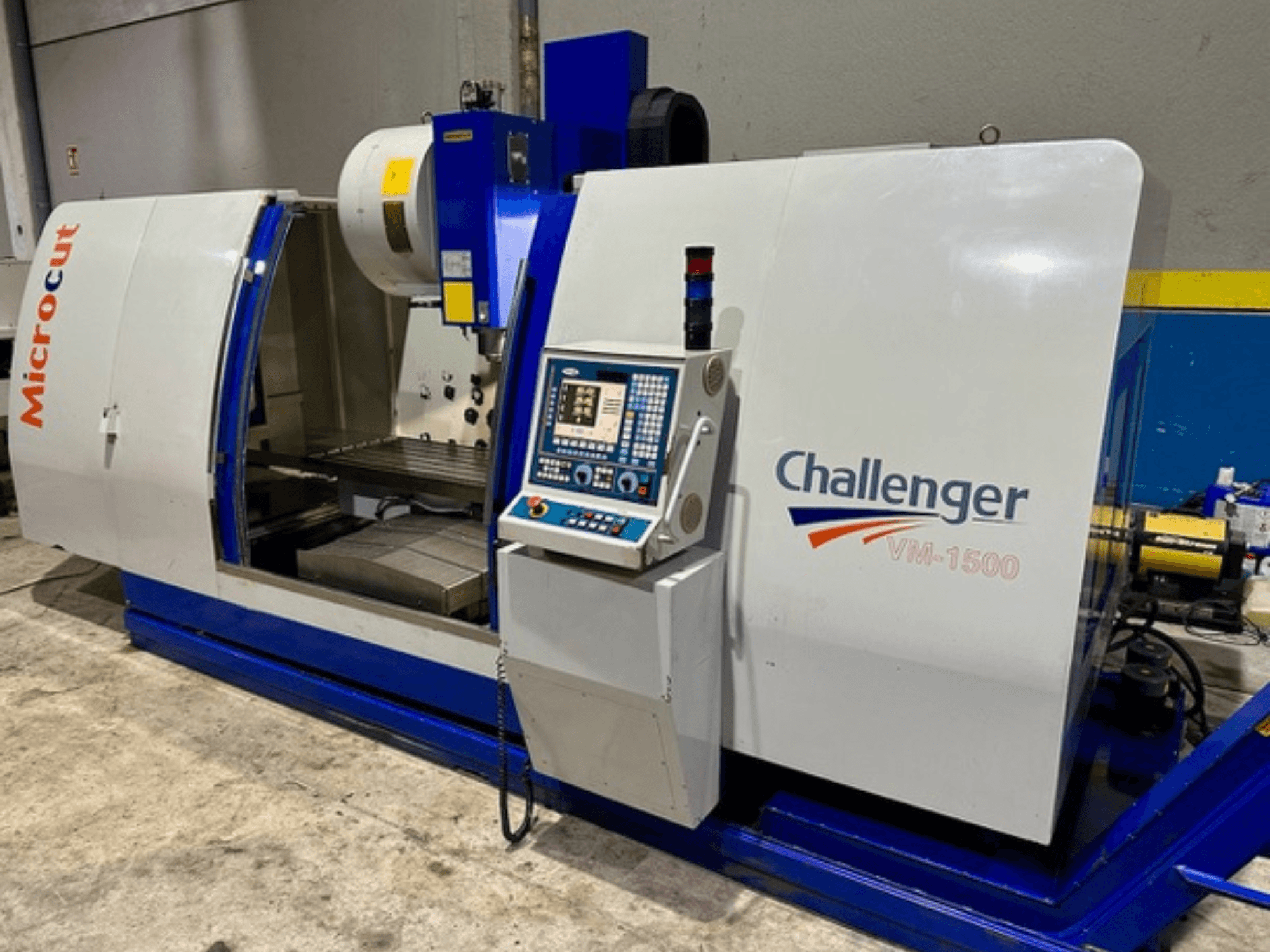 Microcut Challenger VM-1500 CNC-kone, etukuva, jossa on ohjauspaneeli, työtila ja sininen pohja.