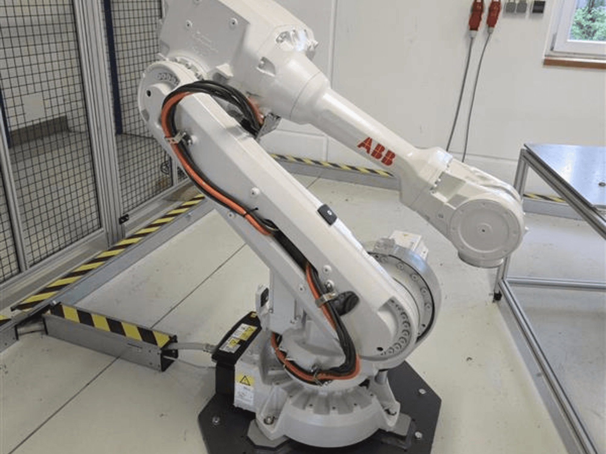 ABB IRB 4600-45/2.05 -robottivarsi profiilikuva, jossa näkyy sen nivelletty rakenne ja alustaan liitetyt kaapelit.