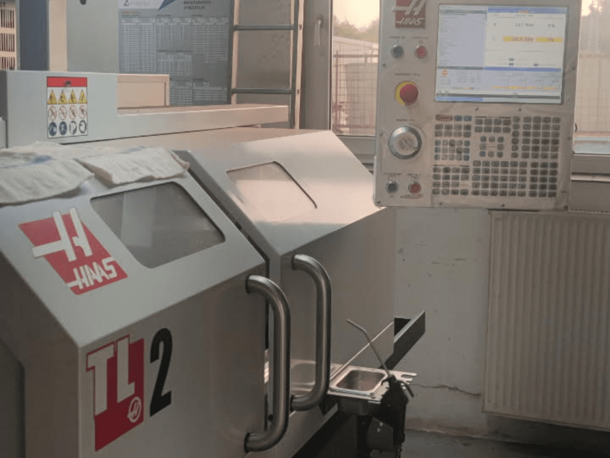 Haas TL-2 vaakasuuntaisen sorvauskoneen etukuva, jossa on ohjauspaneeli, metallikotelo ja turvamerkintä.