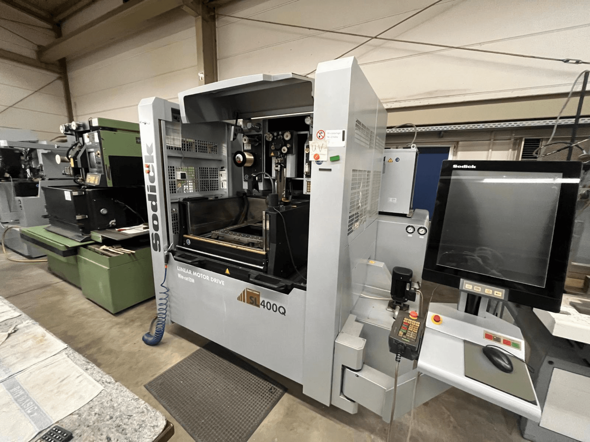 Sodick SL400Q lineaarimoottorikäyttöinen CNC-kone, etukuva digitaalisella ohjauspaneelilla ja näytöllä työpajassa.