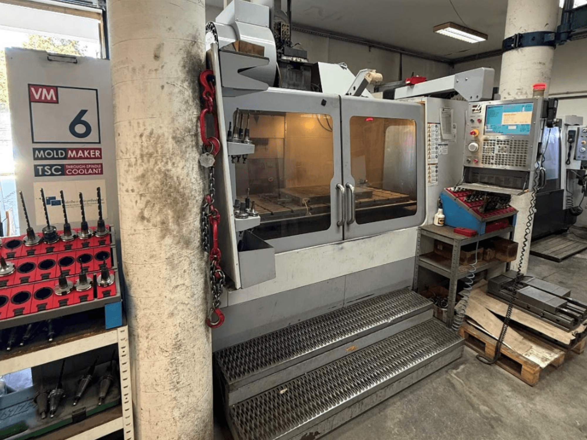 HAAS VM-6 HE -pystykoneistuskeskus edestä katsottuna; kuvassa näkyvät ohjauspaneeli, jäähdytysjärjestelmä ja työkaluvarasto.