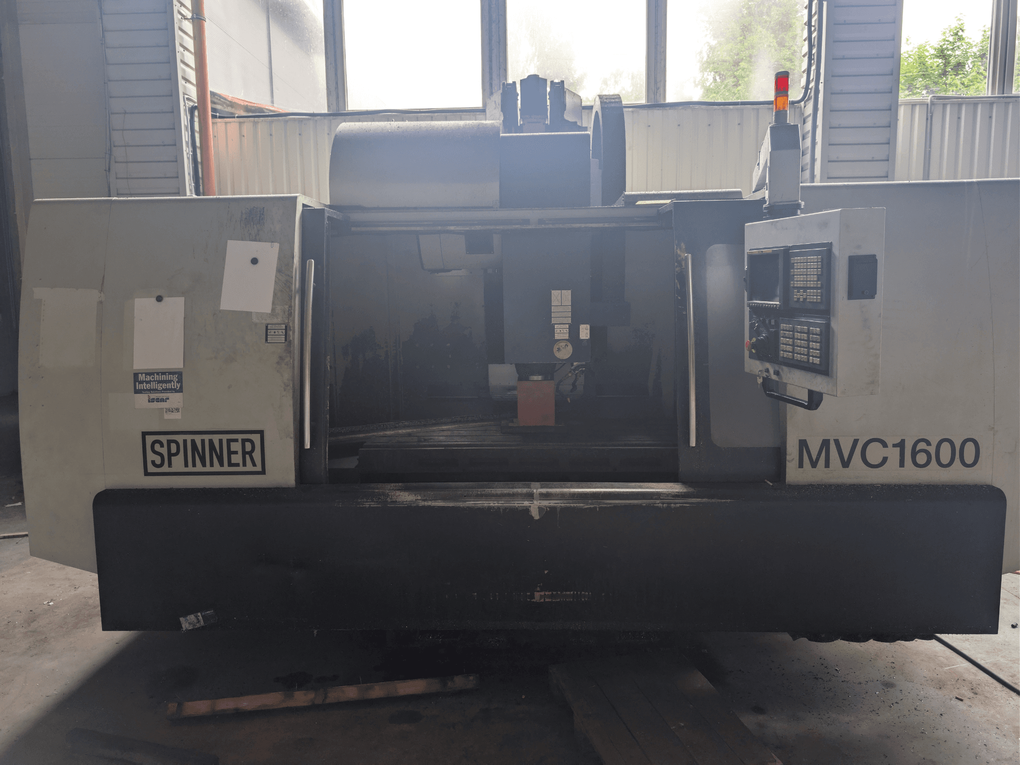 SPINNER MVC-1600 -pystykoneistuskeskus, etunäkymä, jossa näkyvät ohjauspaneeli ja koneistusalue. Soveltuu tarkkuuskoneistukseen.