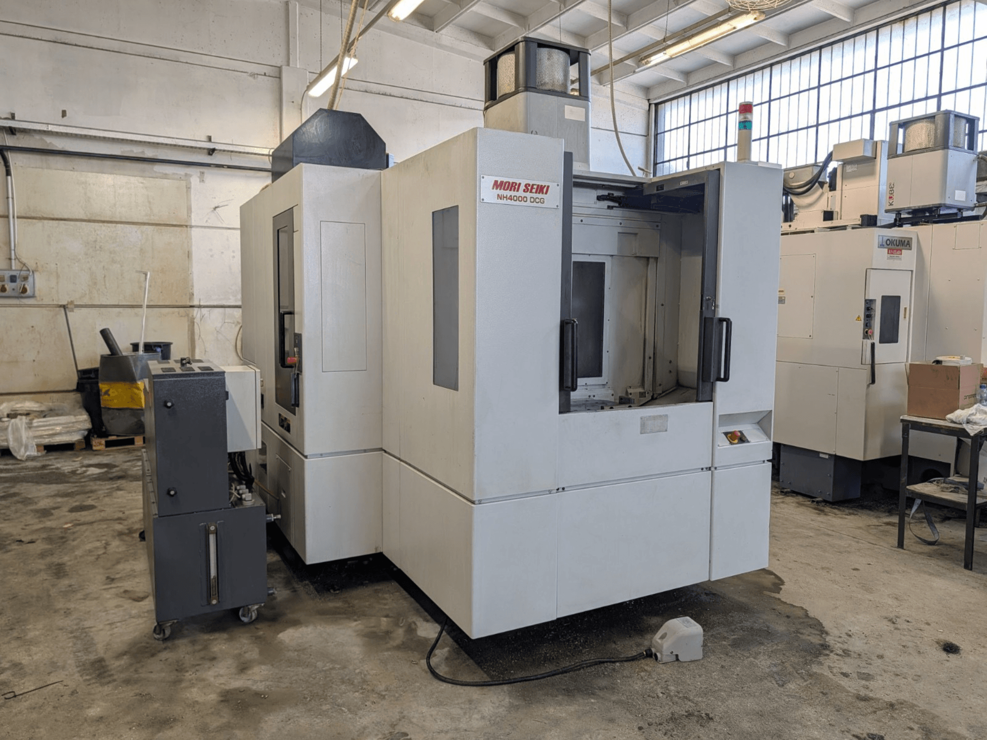 MORI SEIKI NH 4000 DCG -vaakakoneistuskeskus, etukuva, jossa näkyy ohjauspaneeli ja työalue, harmaa ja valkoinen viimeistely.