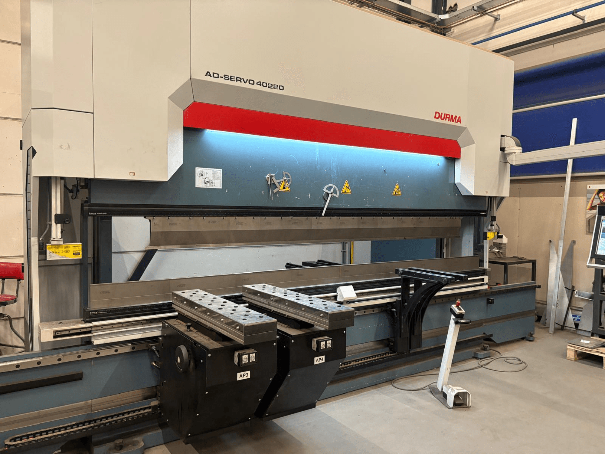 Durma AD-SERVO 40220 -taivutuskone, etunäkymä, jossa näkyvät ohjauspaneeli, hydrauliikkajärjestelmä ja työpöydällä olevat työkalut.